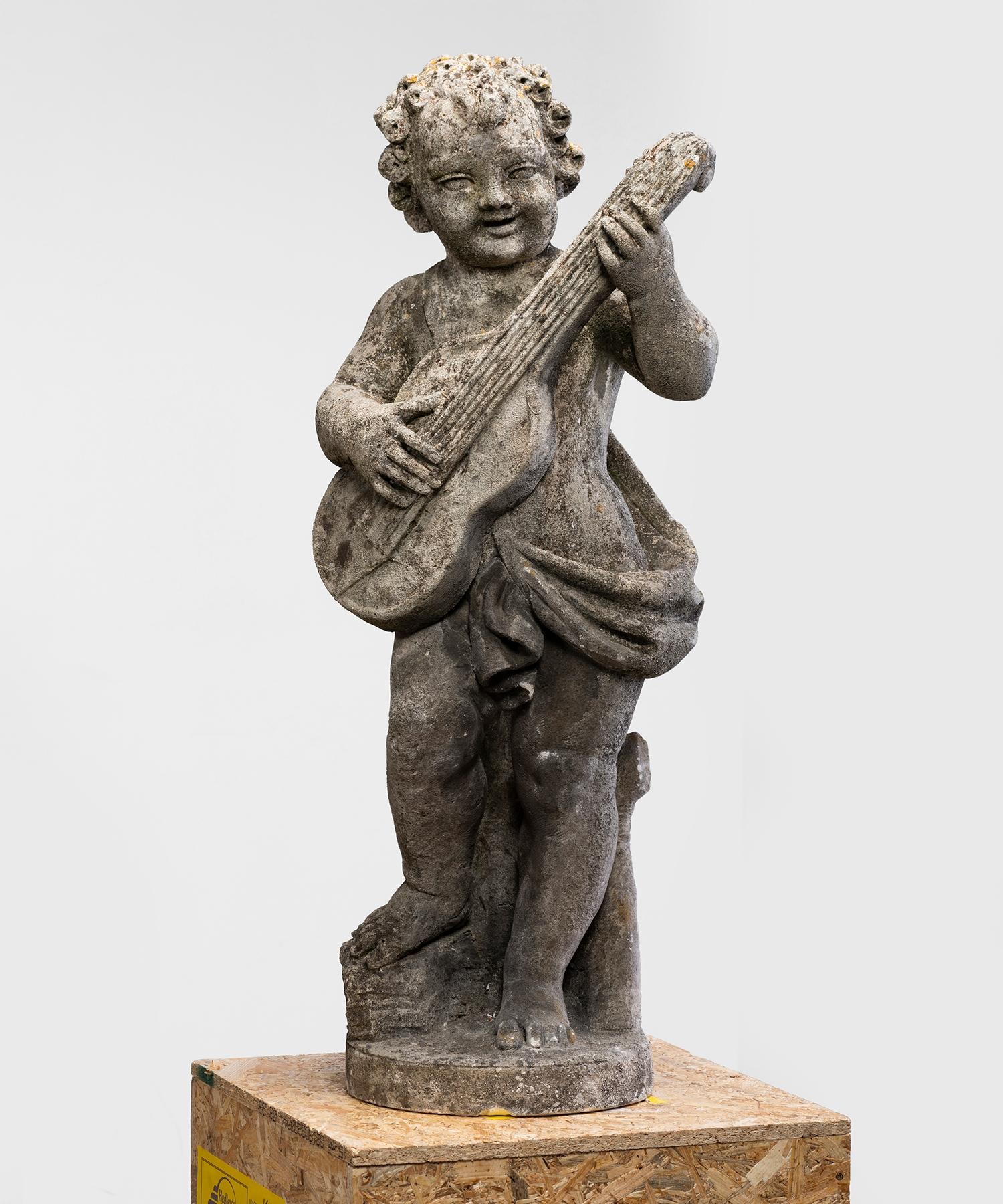 Cast stone garden statue of cherub with guitar. wonderful patina.