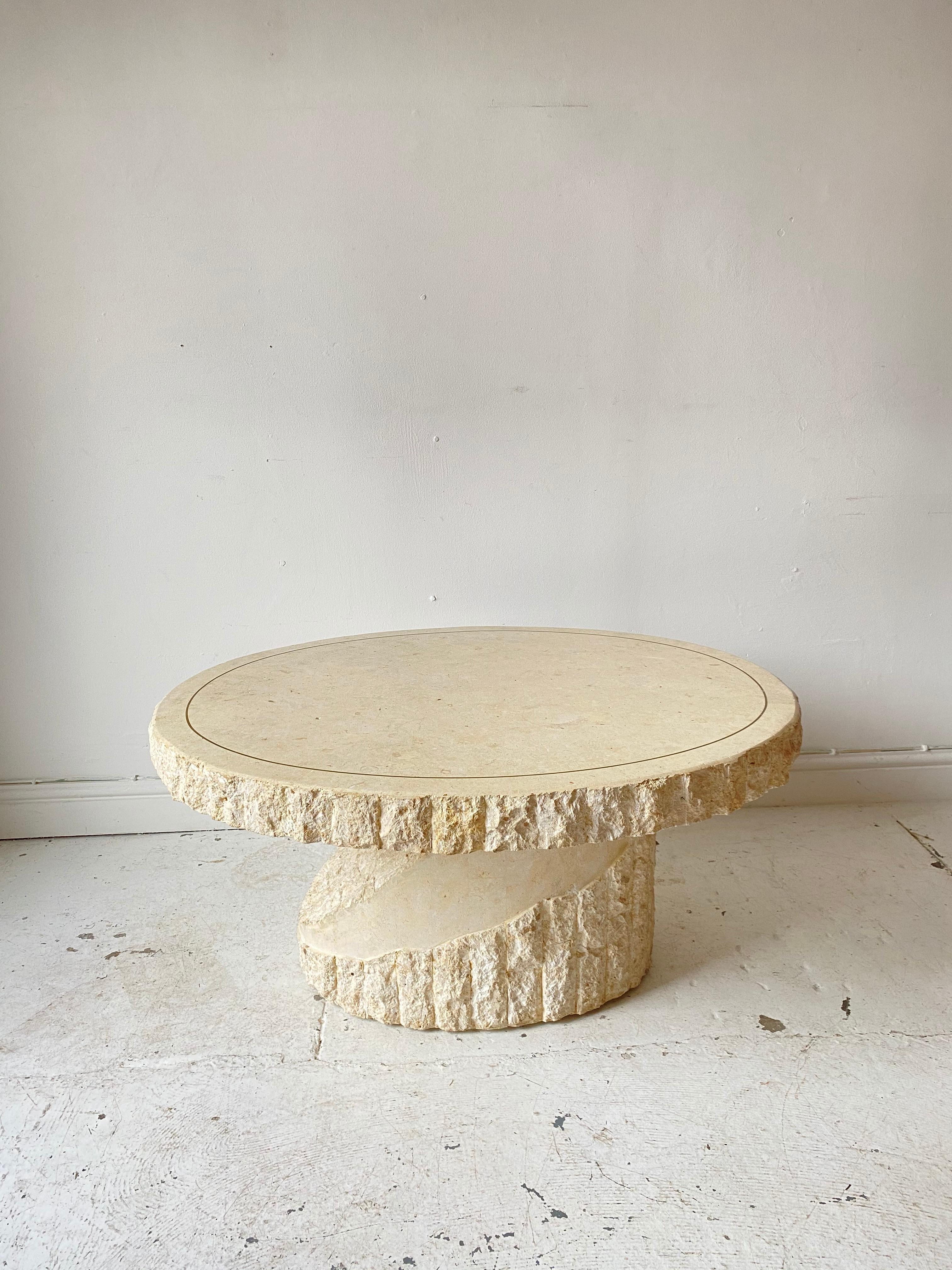 A gorgeous Mactan stone coffee table in the style of Maitland Smith, it features a counterbalance design top and brass inlay. 

Mactan is a natural stone, although this piece looks heavy and monumental, the Mactan stone material is actually