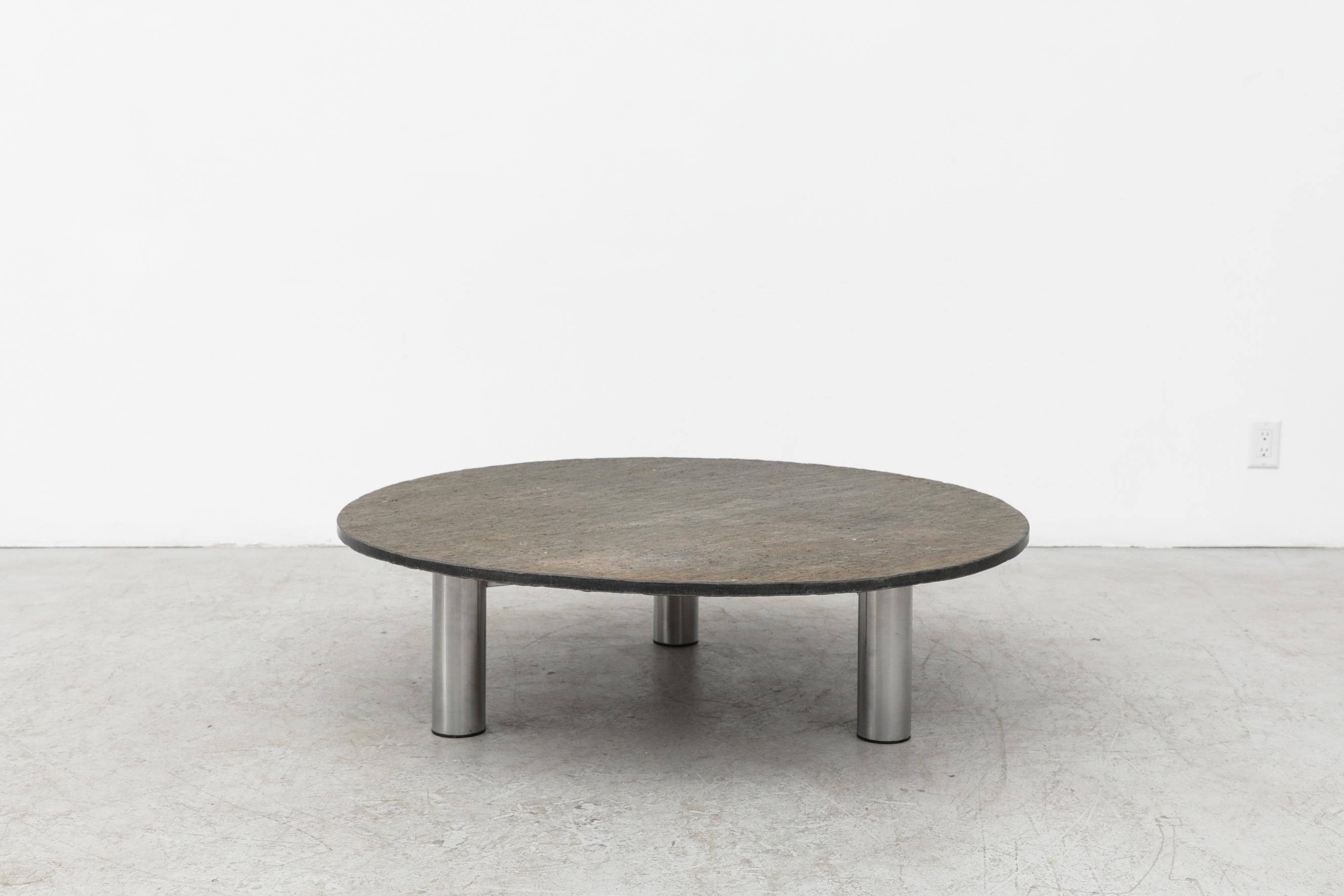 Stone coffee table with tubular steel base. There are bolts in the frame top which act as leveling tools. In original condition with visible patina and some wear to the frame, consistent with its age and use. Other similar stone tables available,