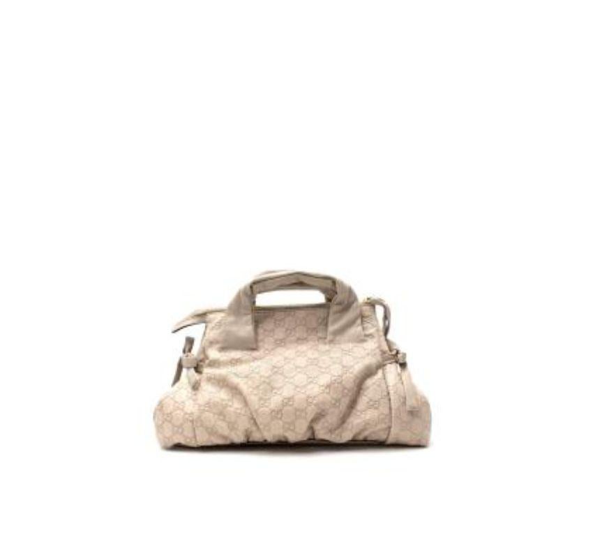 Gucci Stone GG Monogram Leather Bag
 
 - GG Monogram leather
 - Slouchy, soft body with ruched base
 - Graphic print twill lining
 - Gold-tone metal plaque
 - Tonal bows on each end
 
 
 Materials 
 100% Leather 
 
 Made in Italy 
 
 PLEASE NOTE,