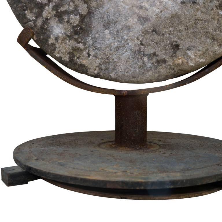 A cast iron custom pedestal levitates this massively heavy stone grinding wheel from France, circa 1900, turning it into a fascinating piece of garden art.
