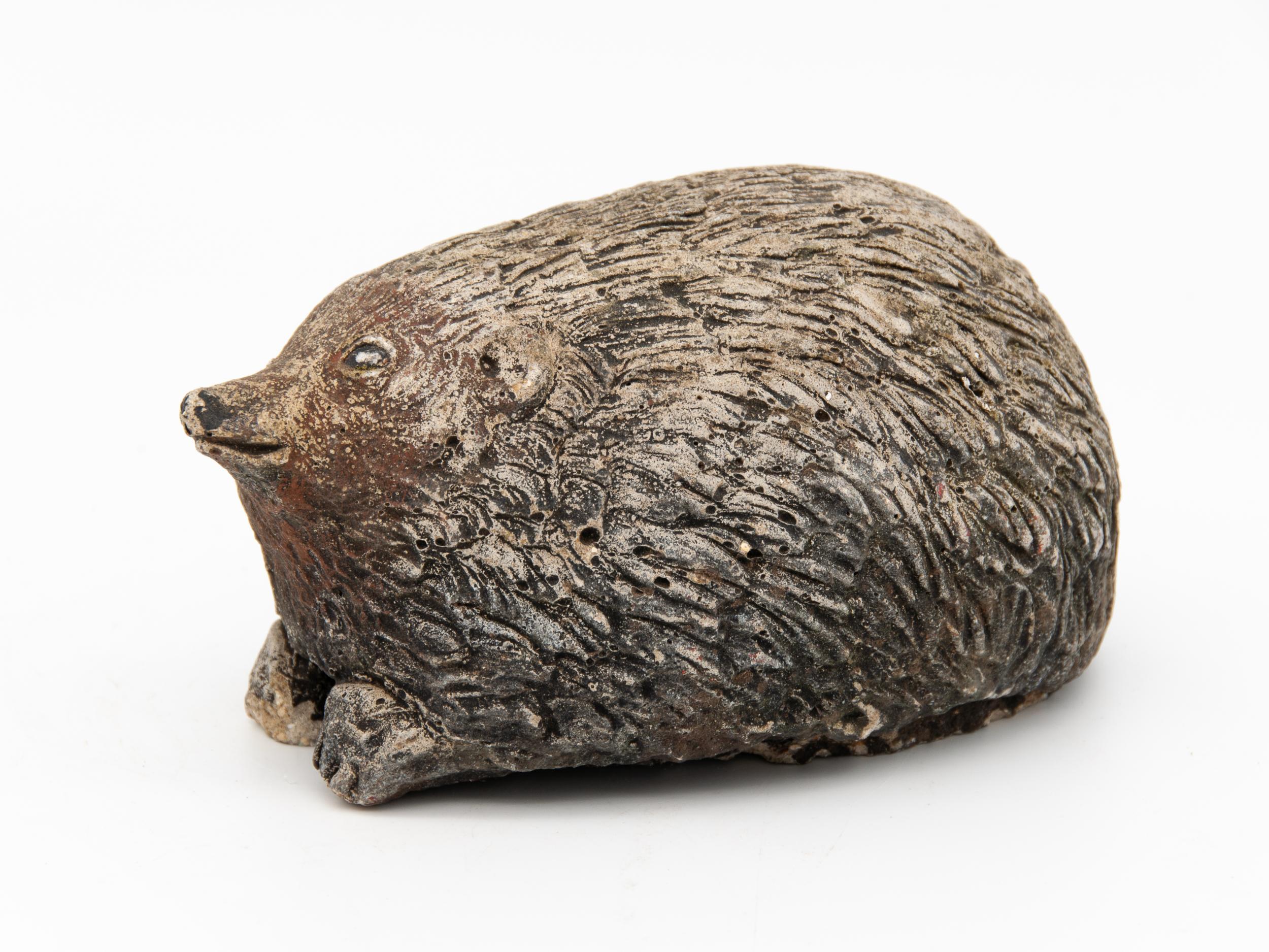 A mid 20th century English cast stone garden ornament in the shape of a hedgehog. An unusual style of hedgehog garden ornament. Wear consistent with age and use.