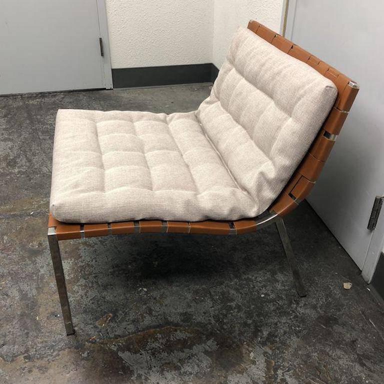 A new Ester chair by Stone International. Woven straps of saddle colored leather envelope a polished steel frame. Accompanied with a removable cushion. Measure: Seat height 17 inches.
 