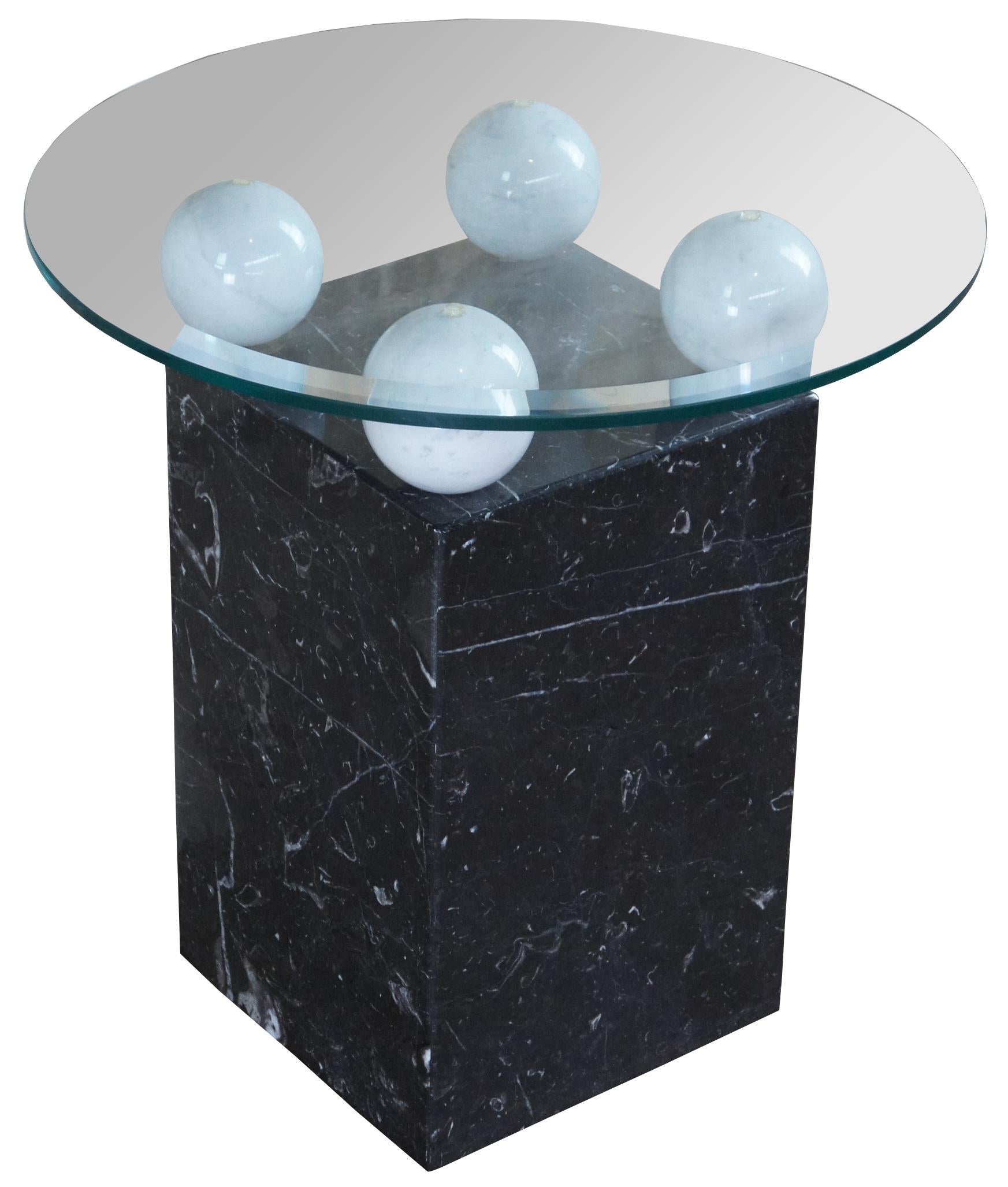 Stone International post modern marble side table, circa 1990s. Features a round glass top with beveled edge supported by an Italian stone base. The rectangular form black and white vein base features white along the top to support the top.
 