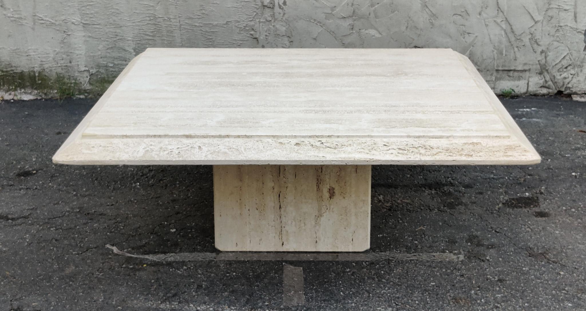 An amazing Italian coffee table with natural and porous travertine edging. The simplicity of the design and surface treatments is what makes this table a classic example of strong and stoic Italian minimalist design, using top materials and