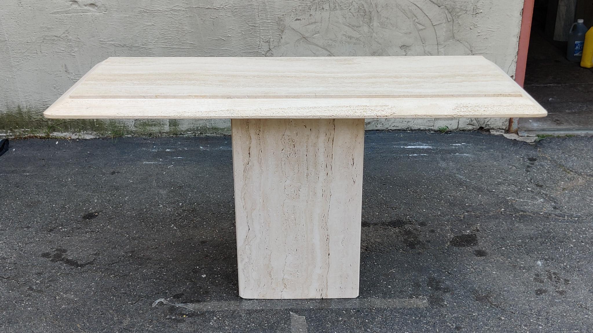 An amazing Italian console table with natural and porous travertine edging. The simplicity of the design and surface treatments is what makes this table a classic example of strong and stoic Italian minimalist design, using top materials and