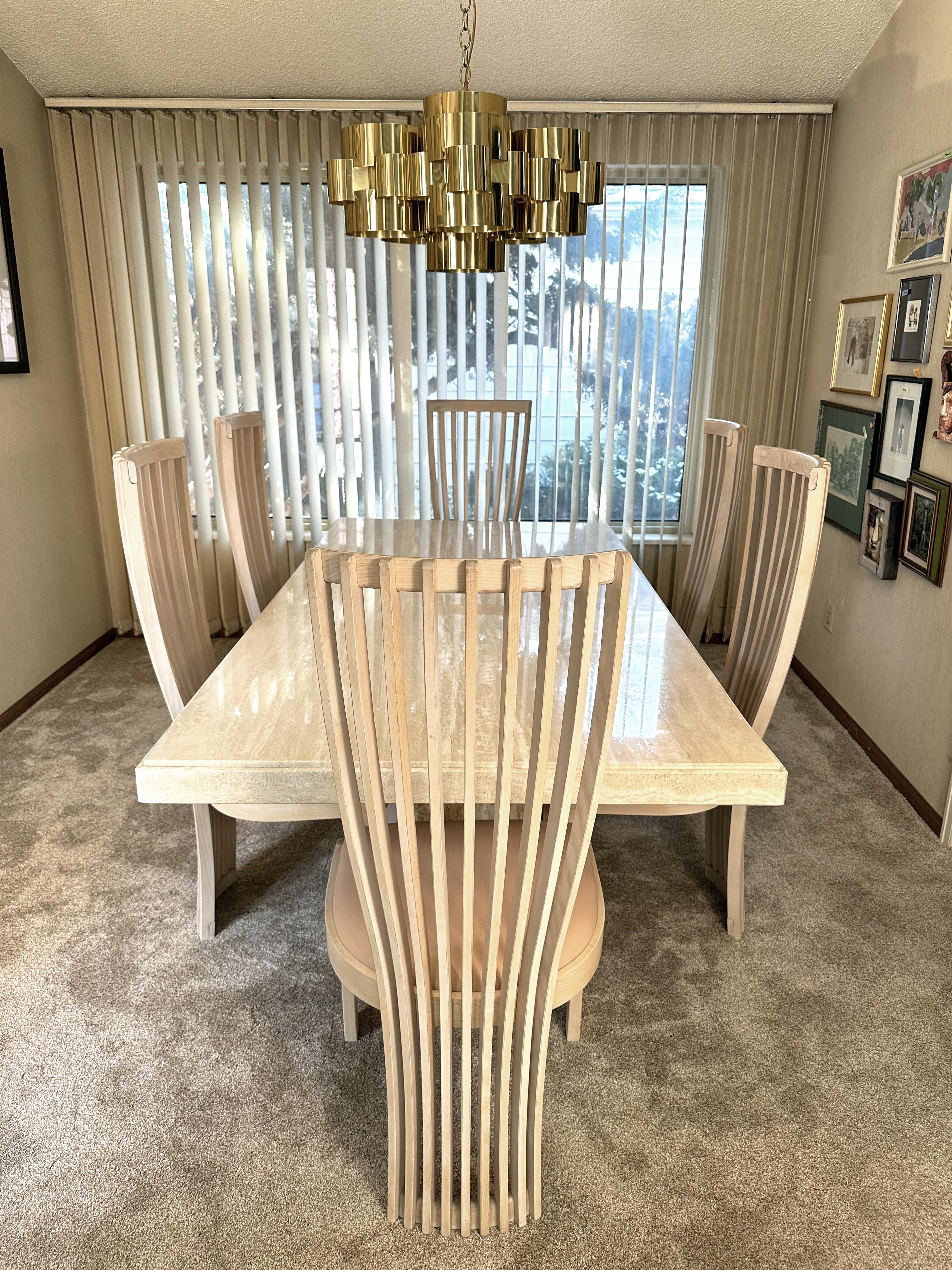 Ce guéridon en travertin de Stone International et les chaises de salle à manger Tonon - toutes deux fabriquées en Italie - forment un ensemble parfait et élégant. 

La table, fabriquée en 1985, est composée d'une grande plaque de travertin poli, au
