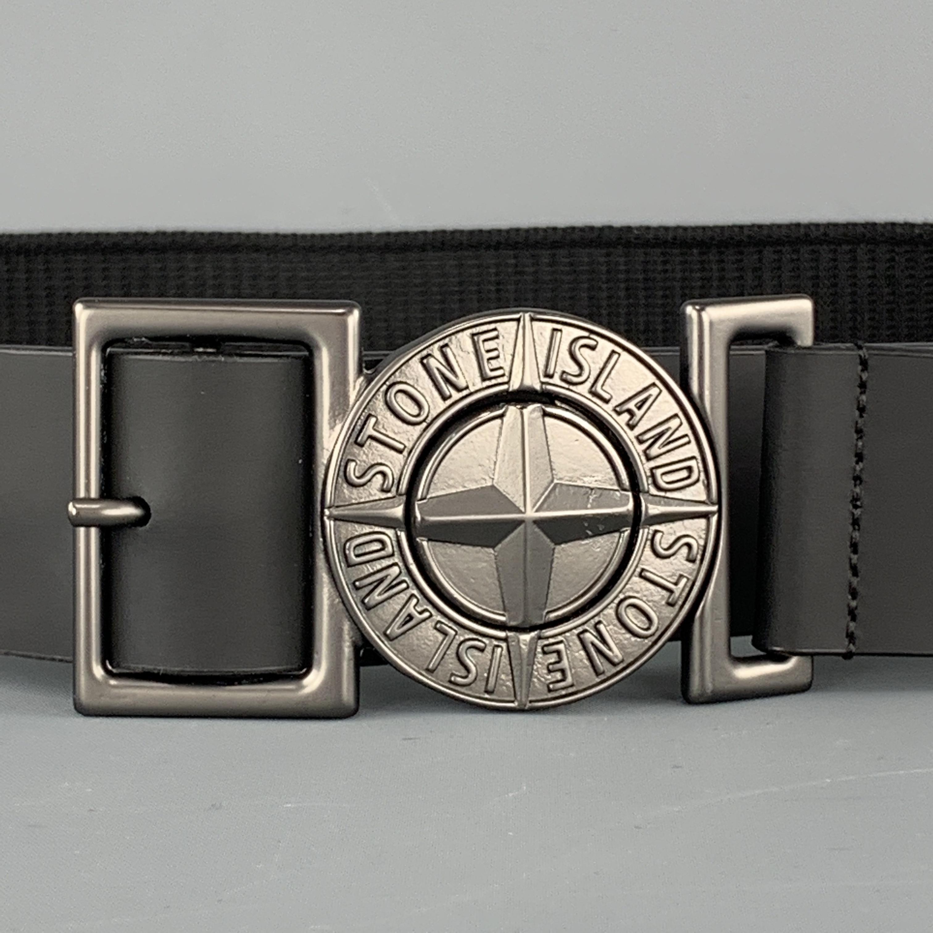 STONE ISLAND belt features a webbing strap with a logo interlock buckle detailed with adjustable rubbersized leather panels. Buckle scuffed. As-is. Made in Italy.

Very Good Pre-Owned Condition.
Marked: 100

Length: 43.5 in.
Width: 1.5 in.
Fits: