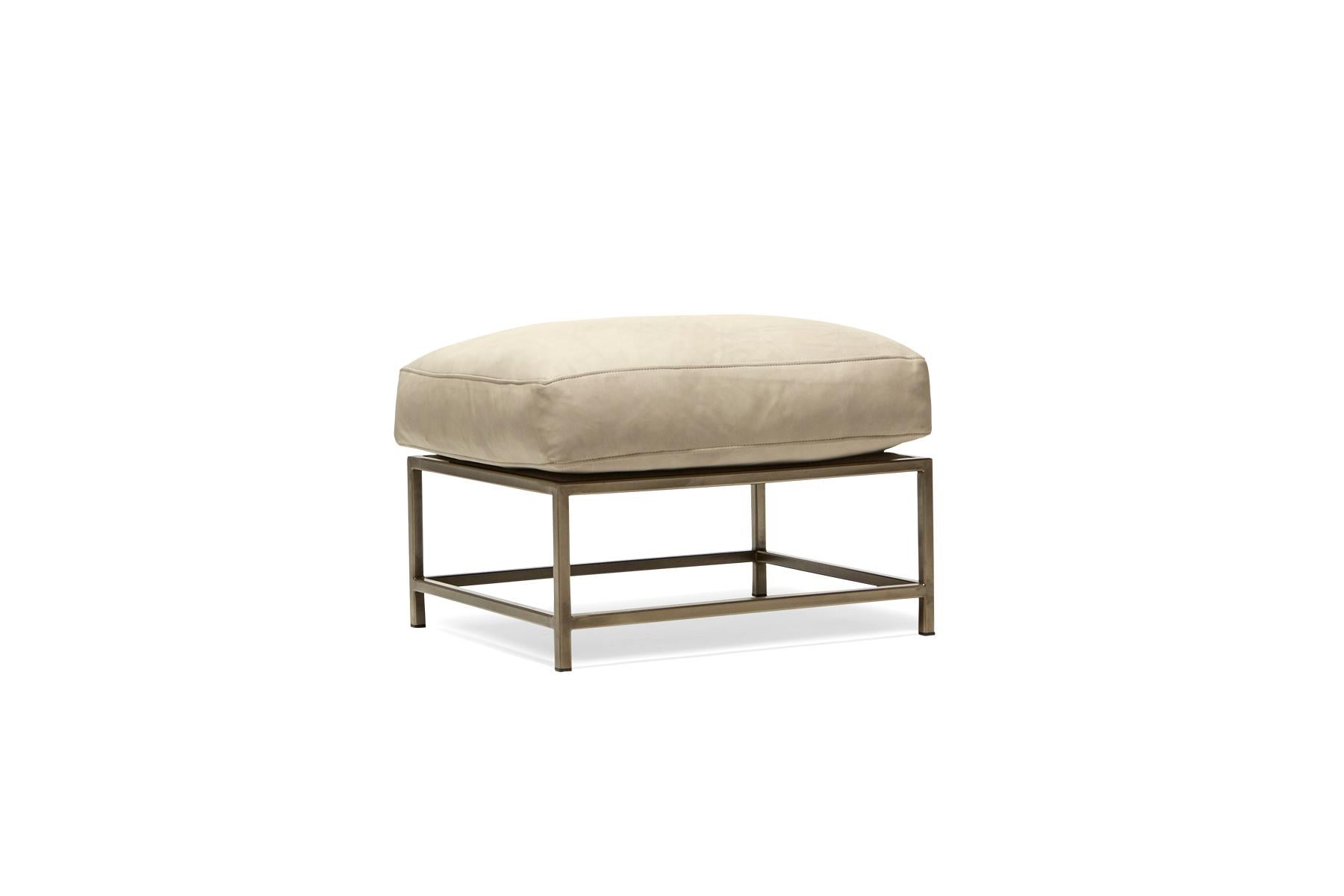 Designed to pair with any of the inheritance seating options, the ottoman is a great addition to add a lounge element to your seating arrangement. 

This variation is upholstered in a light stone leather by Moore & Giles. The foam seat cushions
