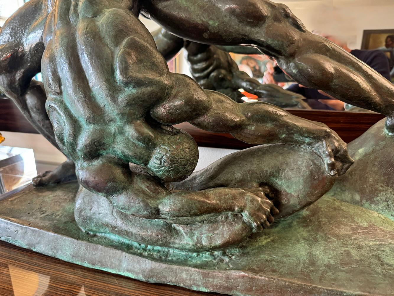 Grande, audace e provocatoria, questa rarissima scultura in bronzo raffigura una potente e muscolosa figura maschile nuda che si sforza di sollevare un'enorme roccia, con le gambe divaricate e il corpo teso per raggiungere l'impossibile.  È stata