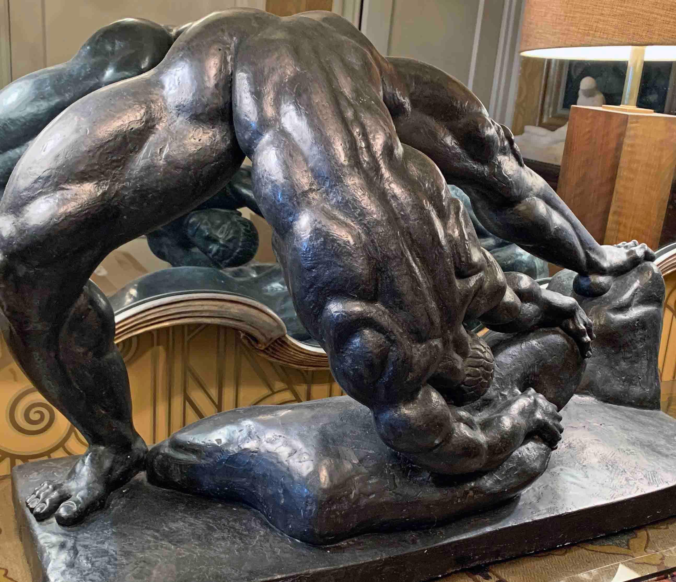 A remarkable depiction of a strong, muscled nude male figure bent over in a monumental effort to move a large stone, this sculpture was made by the Hungarian-American sculptor Henry Schoenbauer. By the 1920s, many sculptors had created some version