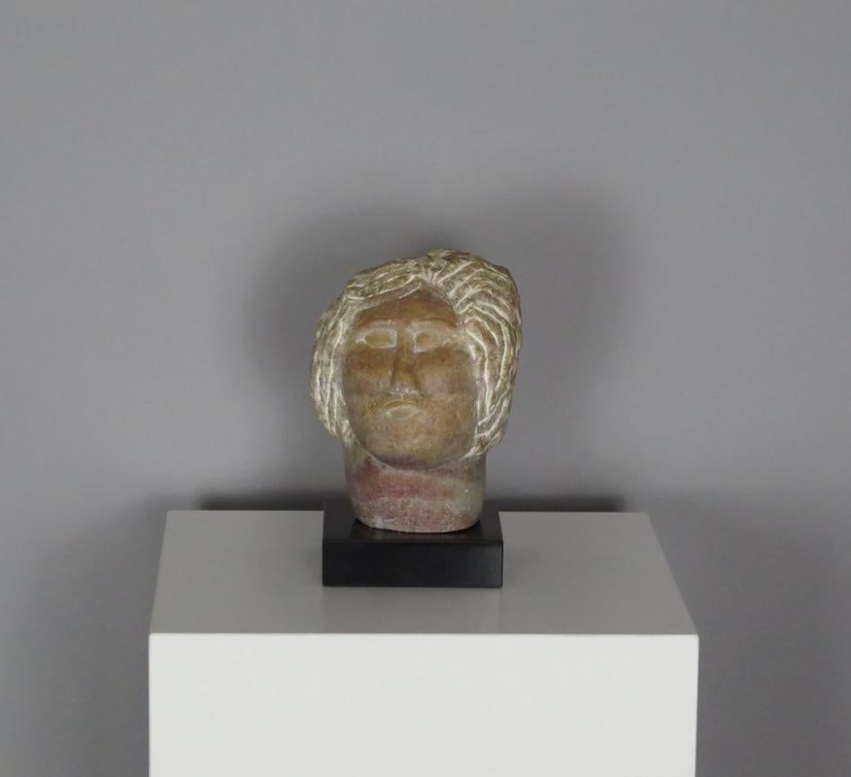 Scultura astratta vintage in pietra di pesca raffigurante una figura mitologica greca. Grecia, circa 1960. Firmato da un artista sconosciuto su una base contemporanea in pietra nera.