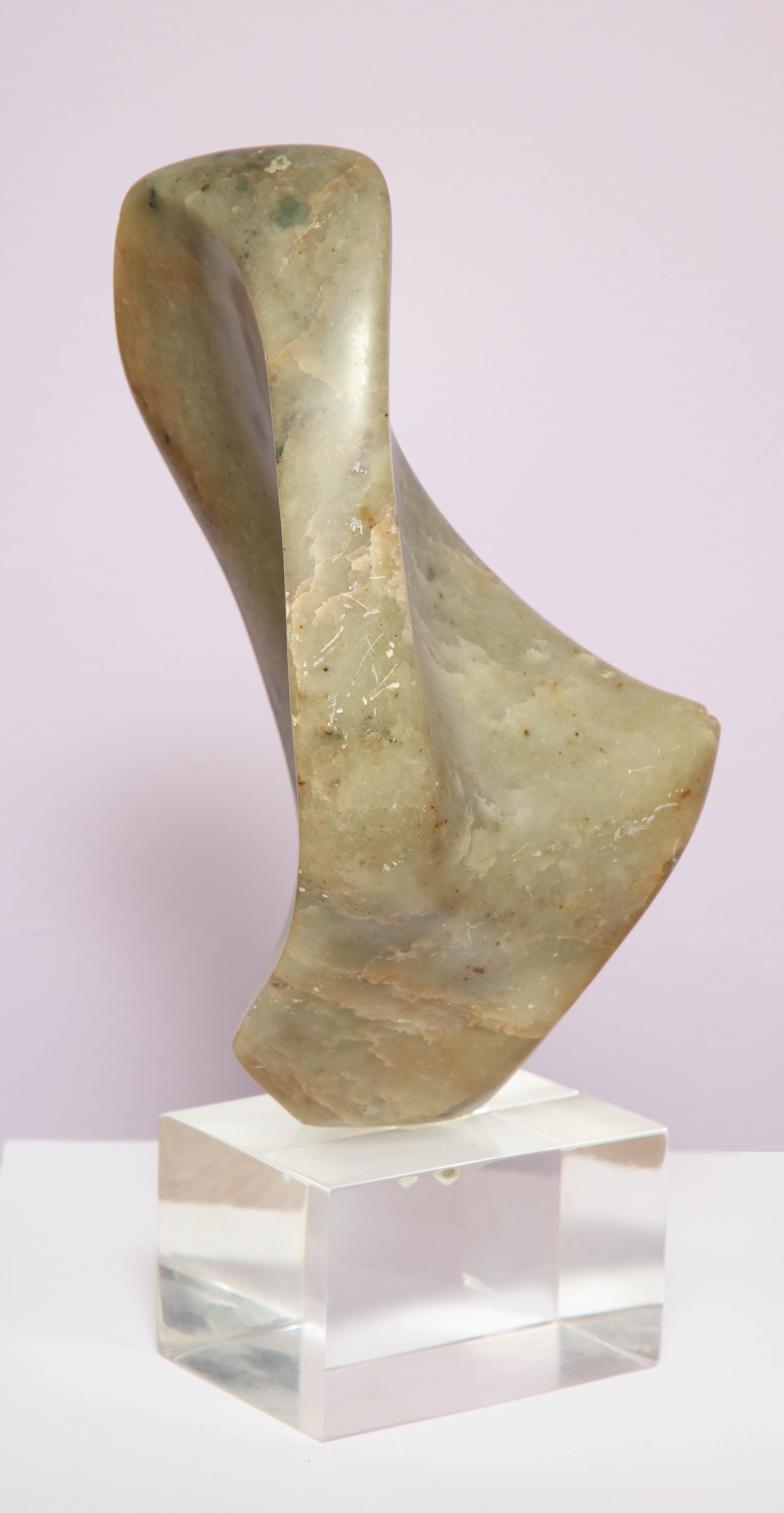 The biomorphic honed stone mounted on a Lucite base.