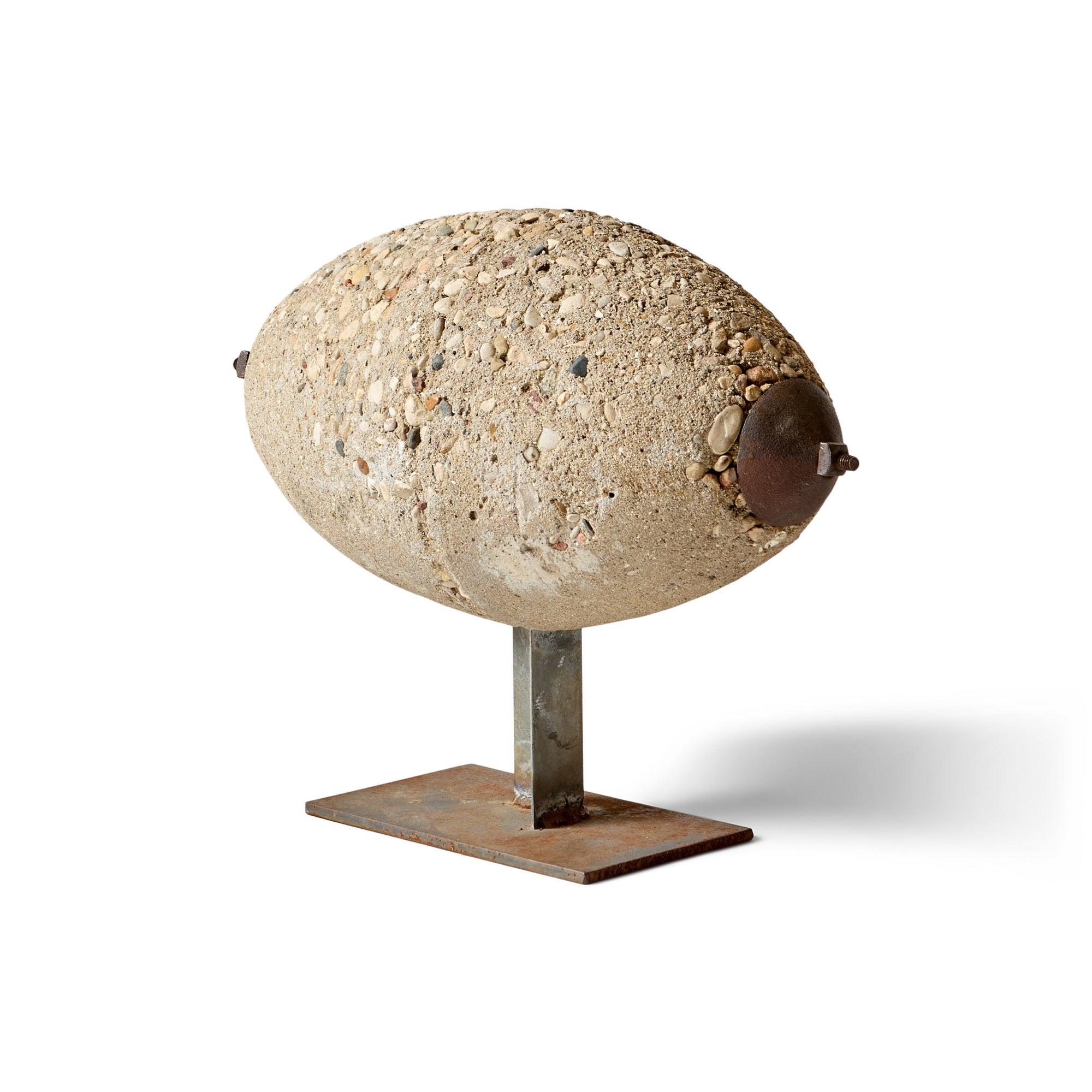 An unsigned stone sculputre on metal pedestal.