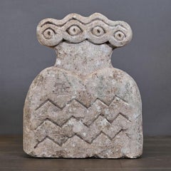 Escultura de piedra de un ídolo de cuatro ojos.