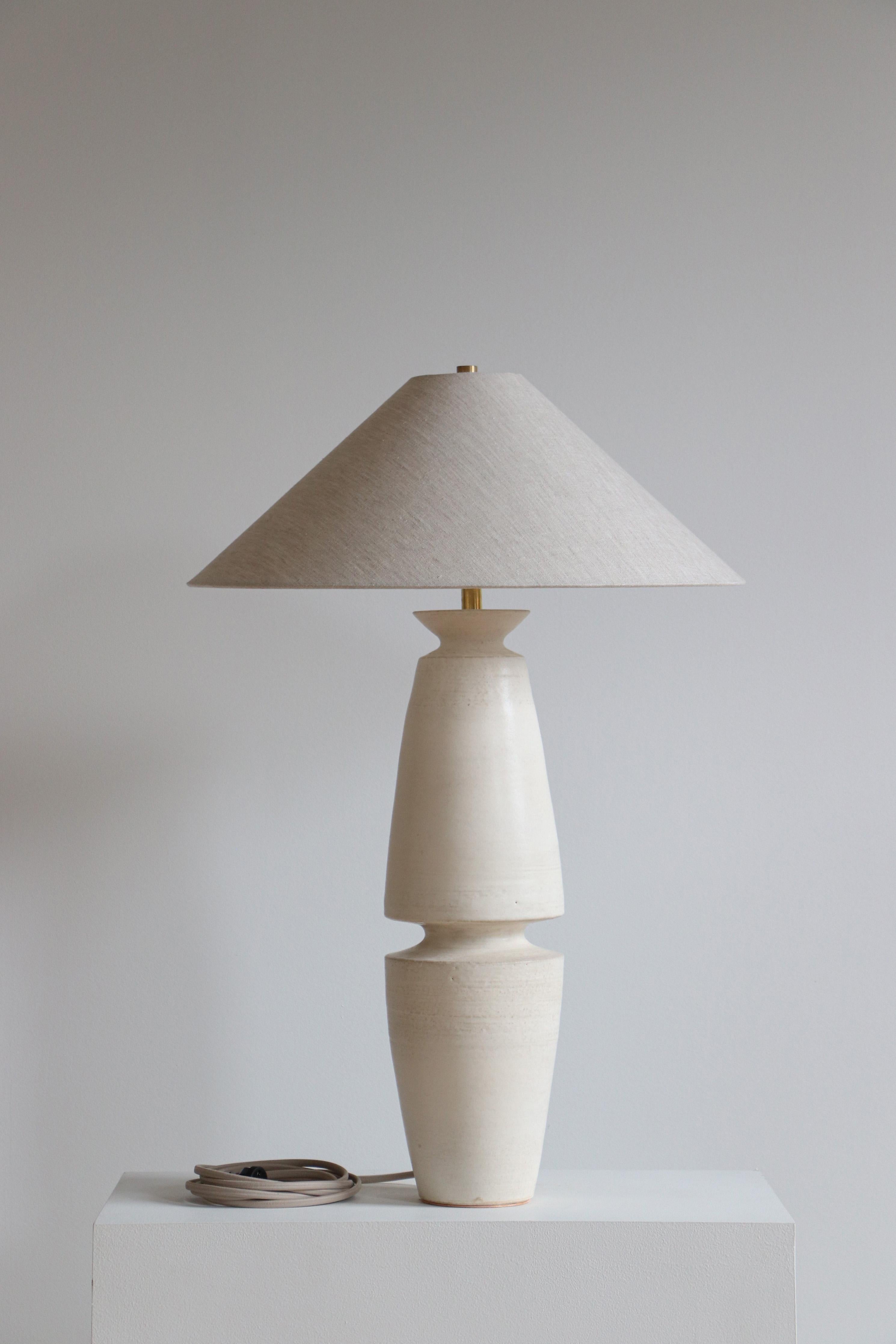 Stone Serena Tischlampe von Danny Kaplan Studio
Abmessungen: ⌀ 51 x H 71 cm
MATERIALIEN: Keramik glasiert, Messing unbearbeitet, Leinen

Dieser Artikel ist handgefertigt und kann innerhalb desselben Stücks Abweichungen aufweisen. Wir tun unser