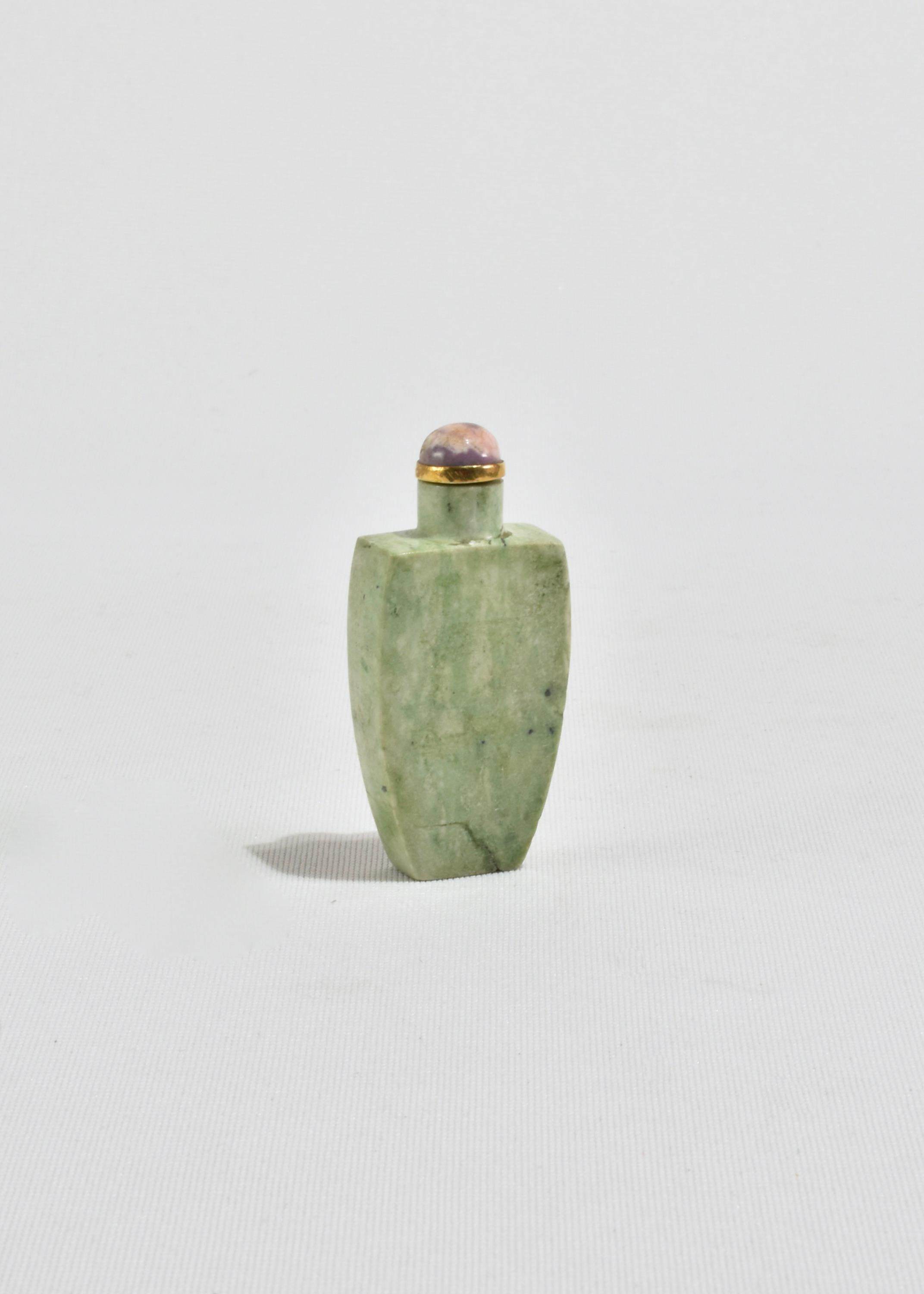 Stunning, vintage hand-carved Chinese snuff bottle in a beautiful green stone with brass detail and purple top. Display on its own as a decorative piece or fill with a favorite scent.