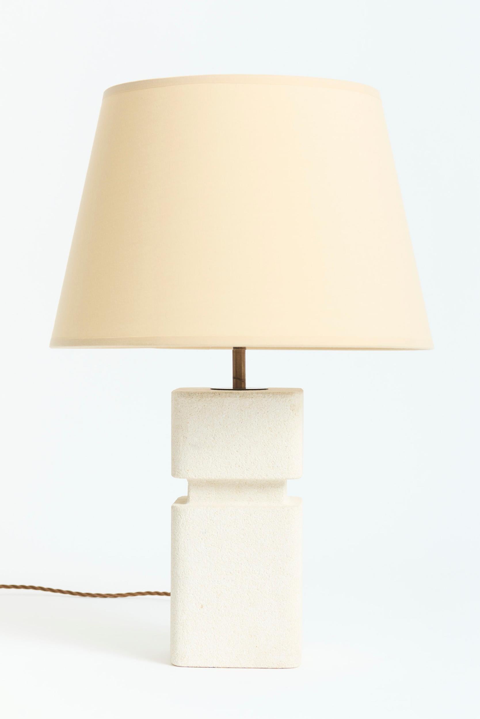 A craved stone table lamp
France, Circa 1970
With the shade: 51 cm high by 31 cm diameter 
Lamp base only: 35.5 cm high by 12 cm wide by 12 cm depth