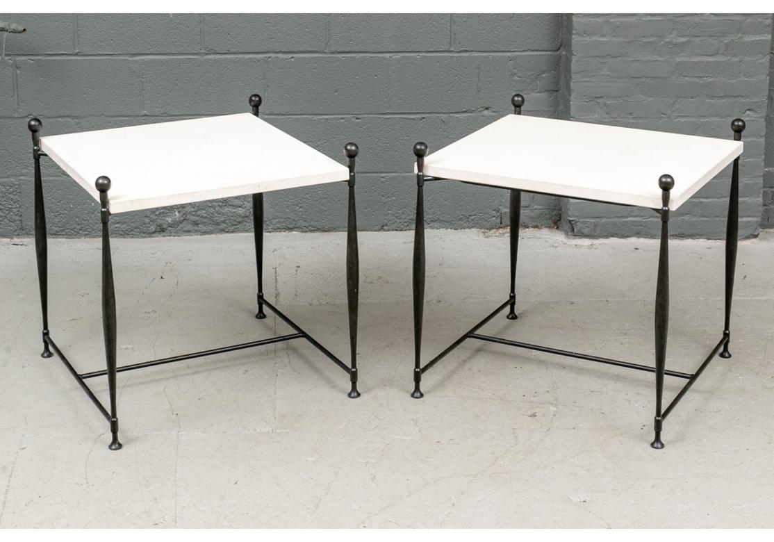 A superlative pair of large Minimalist form iron tables with inset filled and sanded travertine stone tops. Shapely supports topped with ball finials form the frames on which the stone tops rest. In very good condition with a few old chips to the