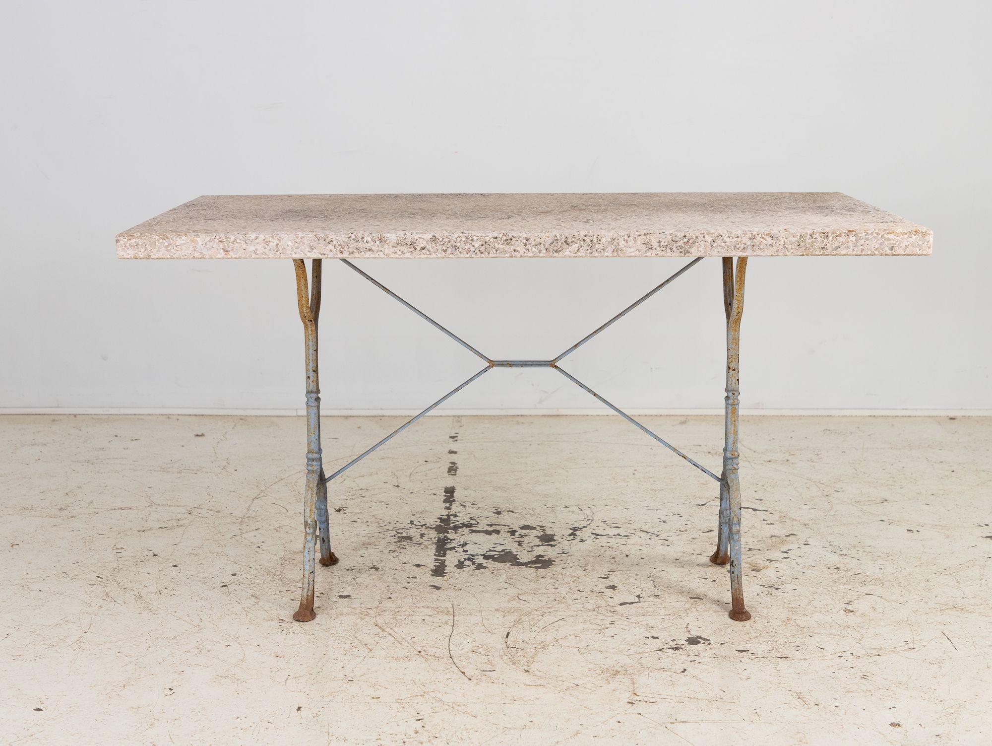 With a smoothed pebbled stone top and gracefully curved, blue-painted wrought iron trestle base, this mid-20th-century French Bistro table brings timeless elegance to any space. Compact yet striking, it evokes the charm of Parisian cafés.