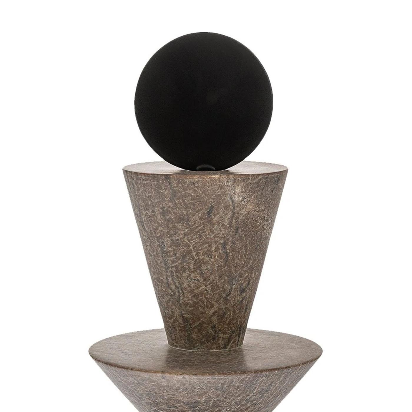 Scultura in pietra Totem D realizzata con la pietra ollare
e con ornamenti in acciaio al carbonio. Totem realizzato
fresando la pietra ollare in forme geometriche.