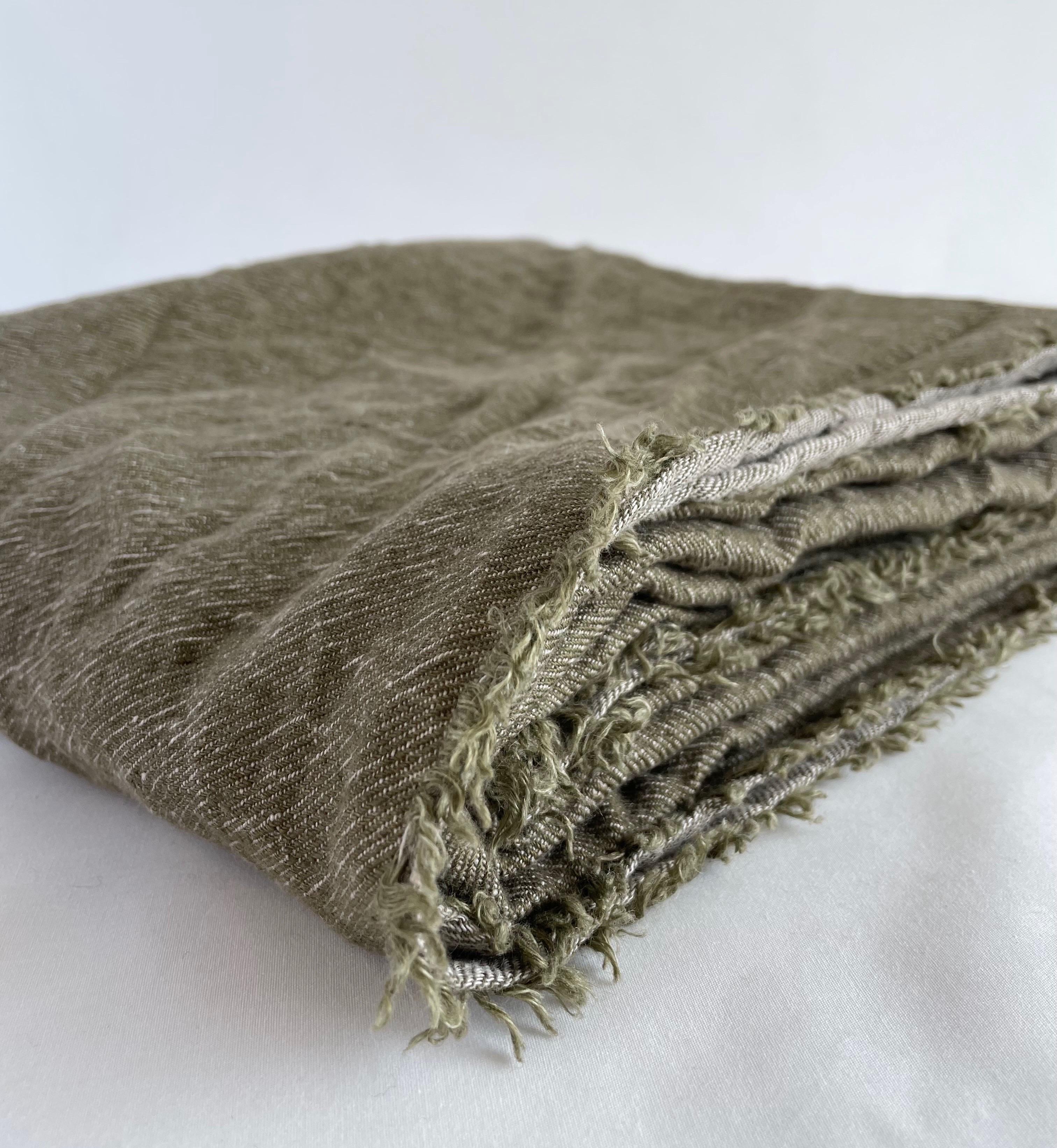 Layer your sofa or bed with this washed Belgian linen throw imported from Paris, France. In the colour Kaki-Givre, which is an olive or army green color with a deeper color on one side, and lighter on the opposite. The decorative frayed edge give