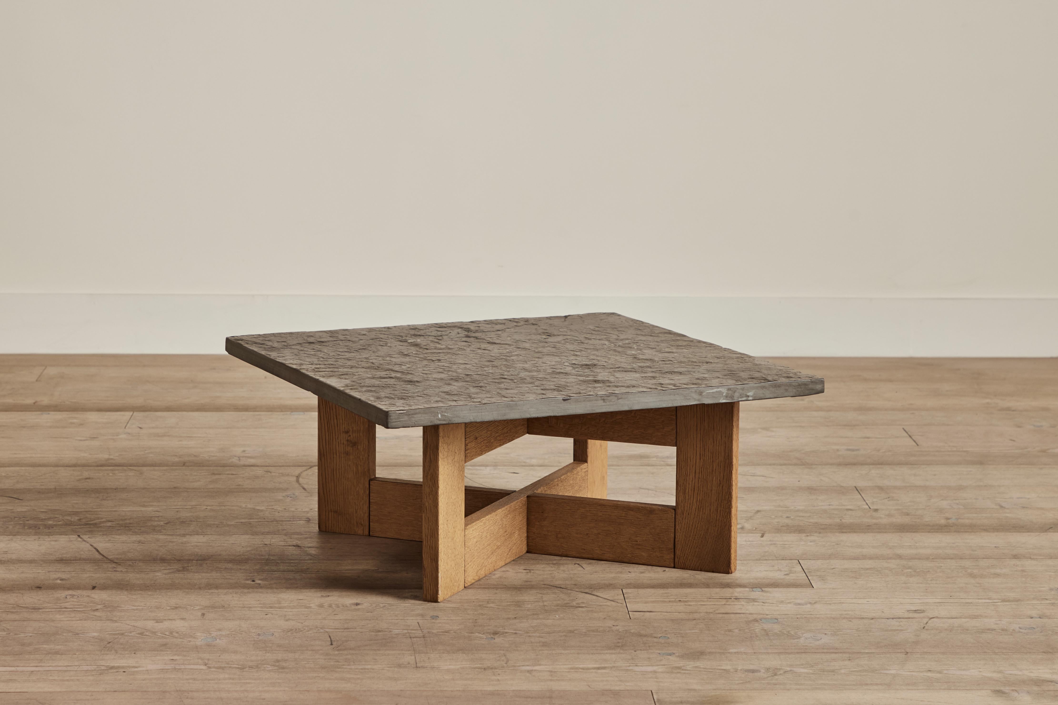 Brutalist coffee table with a raw stone top and oak wood base, Germany circa 1960. Wear on stone and wood that is consistent with age and use. 