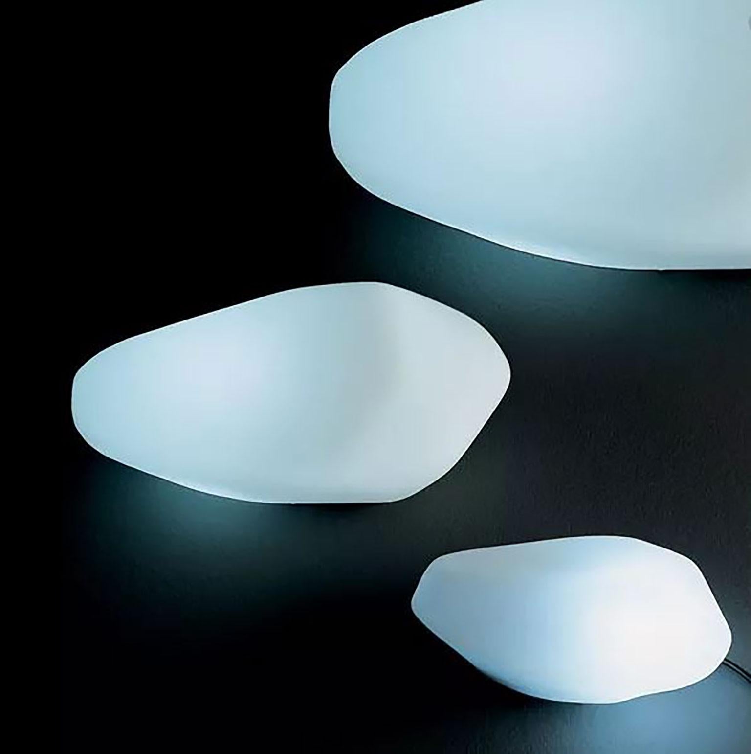 Stones outdoor lamp by Marta Laudani & Marco Romanelli for Oluce. The design of this lamp is inspired by nature and these luminous stones can be placed either single or in a group. Made from white polyethylene. Available in three