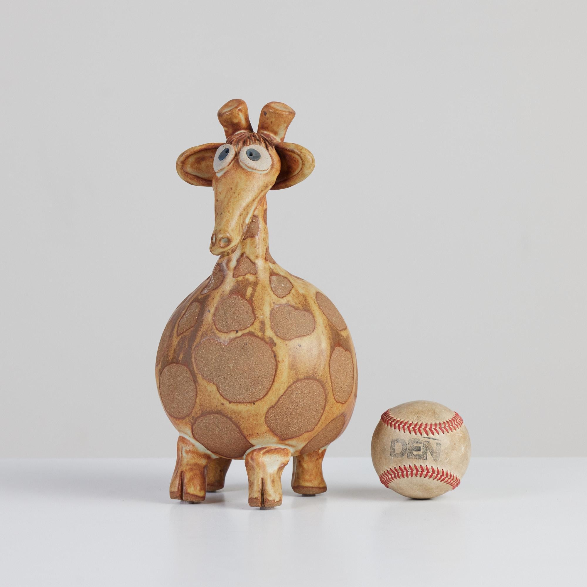 Hand built studio ceramic of a giraffe. This piece is mixed with both natural colored stoneware and yellow orangish glazed elements. The playful sculpture can simply be shelf décor or used as its intended purpose, a piggy bank.

Signed by artist