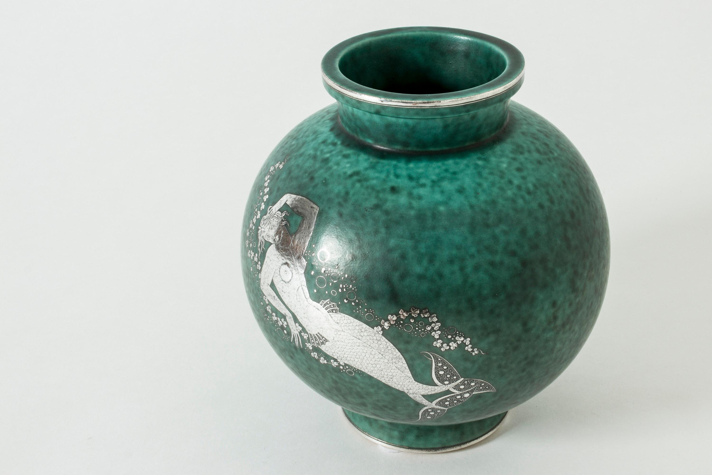 Stoneware “Argenta” vase by Wilhelm Kåge with silver decor of a mermaid. Lovely attention to every detail, exquisitely made tail fin and swooning expression in her face.

“Argenta” was introduced at the Stockholm exhibition in 1930 and became