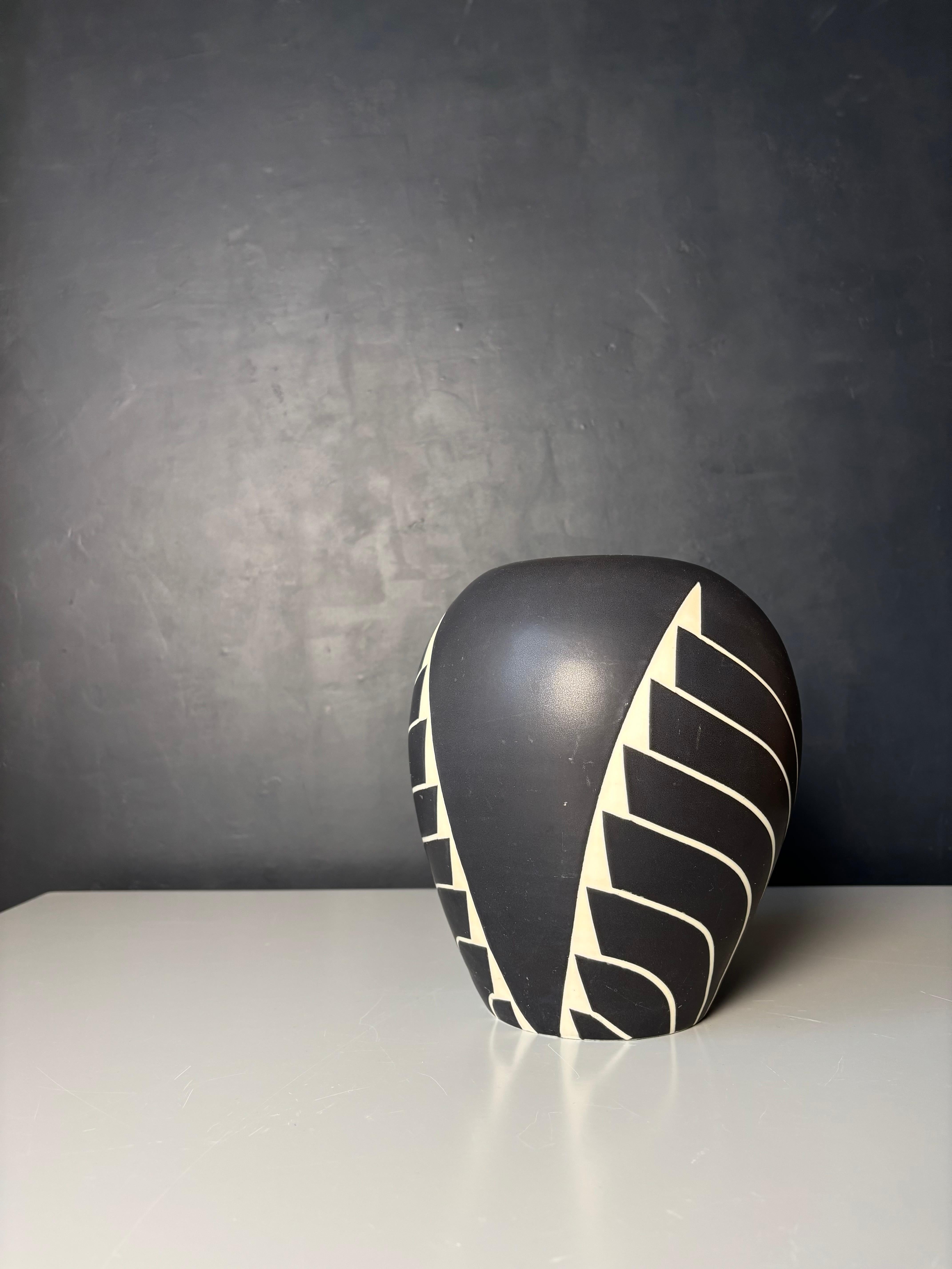Vaso moderno scandinavo in ceramica pesante con decorazione geometrica ad ali stilizzate bianche in stile art deco tribale su smalto nero. Firmato sotto la base. 
Bellissime condizioni vintage. 
Danimarca, anni '80. 