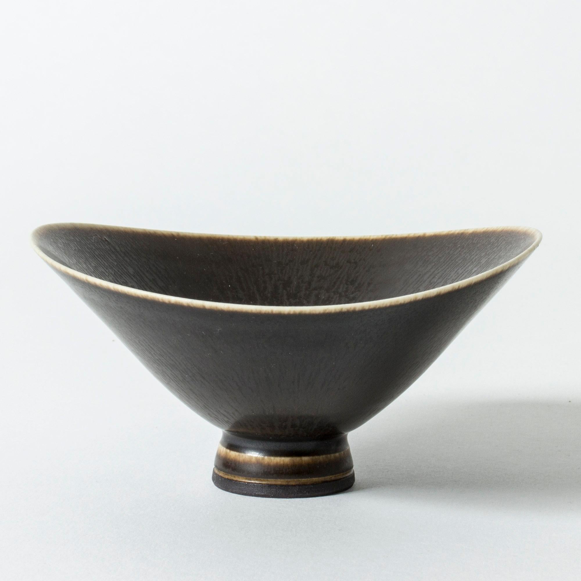 Beautiful stoneware bowl by Berndt Friberg. Oval form, undulating edge. Dark brown hare’s fur glaze.

Berndt Friberg was a Swedish ceramicist, renowned for his stoneware vases and vessels for Gustavsberg. His pure, composed designs with satiny,
