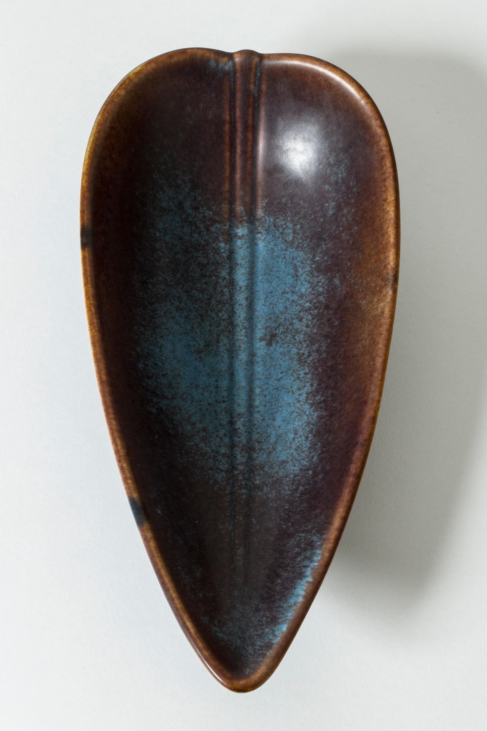 Beautiful stoneware platter in a leaf shape by Gunnar Nylund. Purplish brown glaze with contrasting bright blue areas.

Gunnar Nylund was one of the most influential ceramicists and designers of the Swedish mid-century period. He was Rörstrand’s