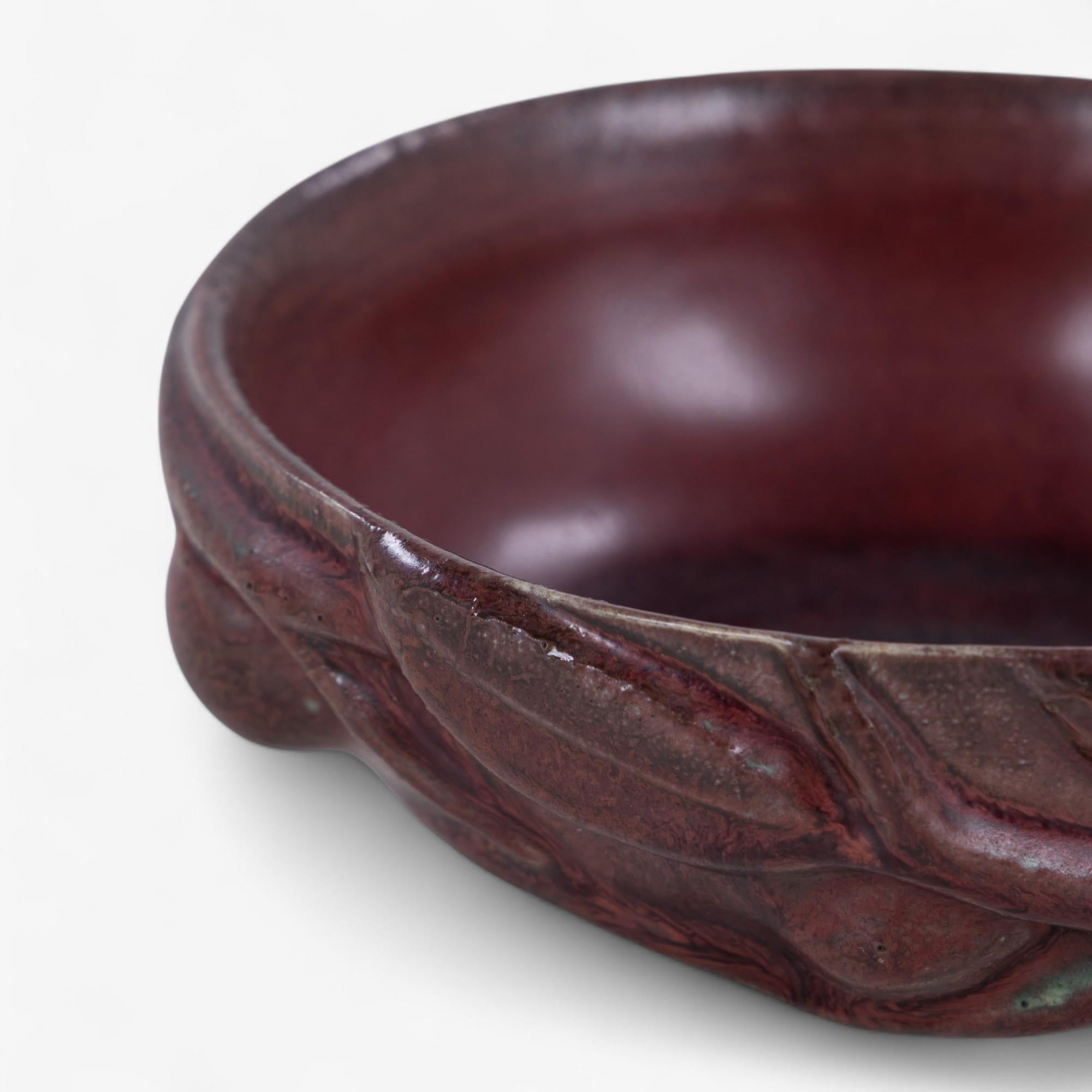Stoneware bowl with modelled fruits in oxblood glaze. Model 20677. Designed in 1944. Signed by Axel Salto og marked by Royal Copenhagen.