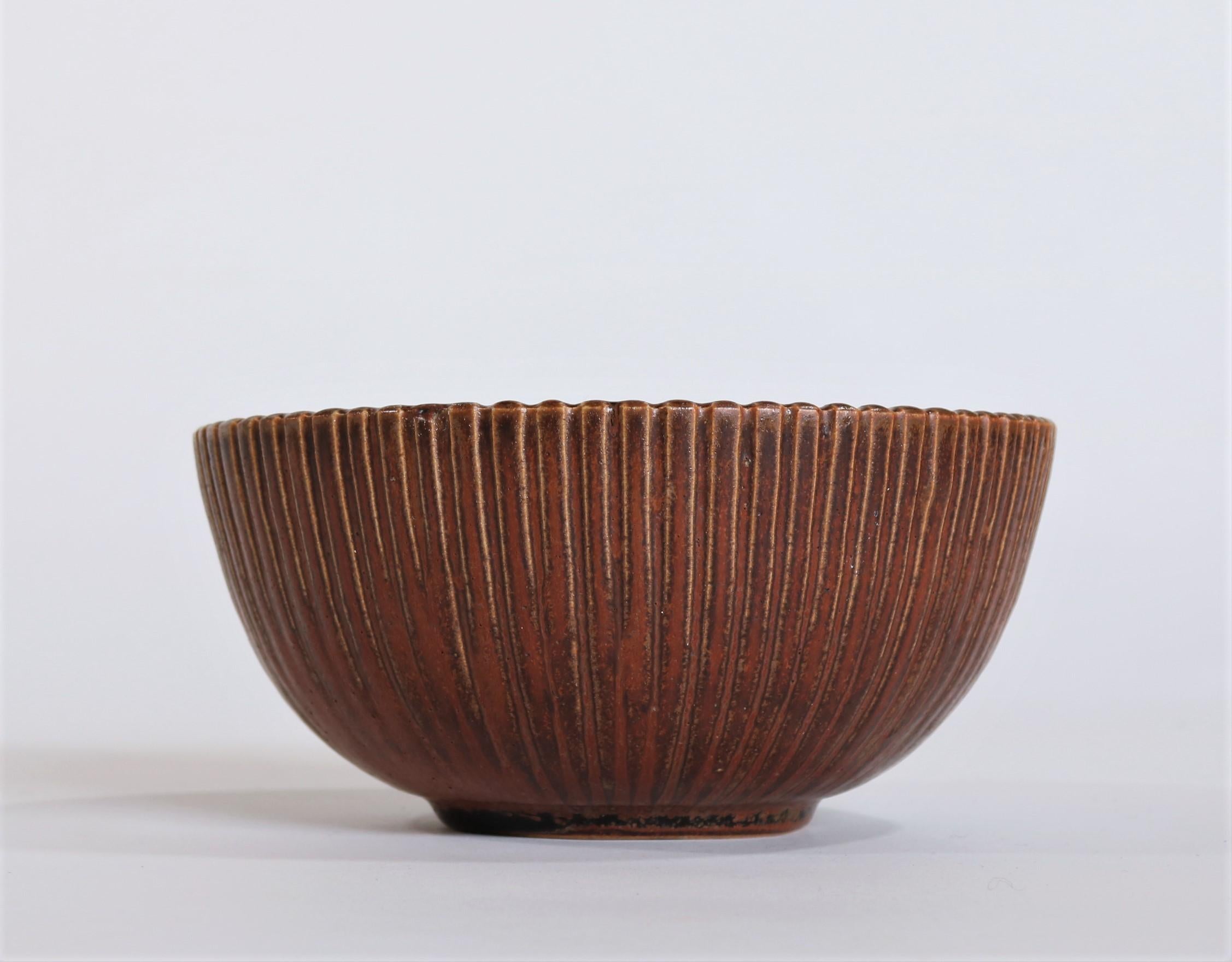 Fluted stoneware bowl with dark red oxblood glaze made by Danish artist Arne Bang at his own studio in Copenhagen the 1930s. Signed with monogram 