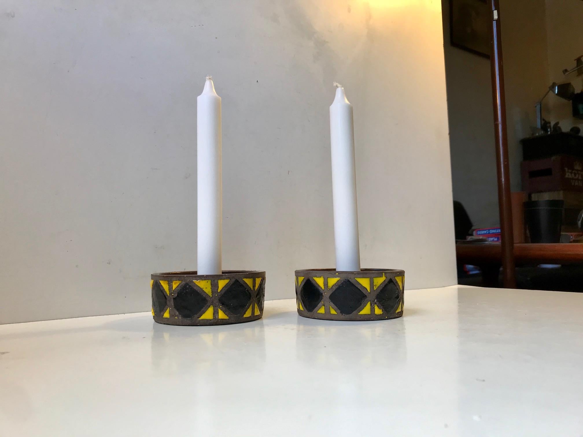 A pair of Italian stoneware candlesticks with yellow and black glaze. This pattern from Aldo Londi is called Wax decor. Manufactured by Bitossi in Italy in the late 1960s. They are to be installed with regular sized candles.
