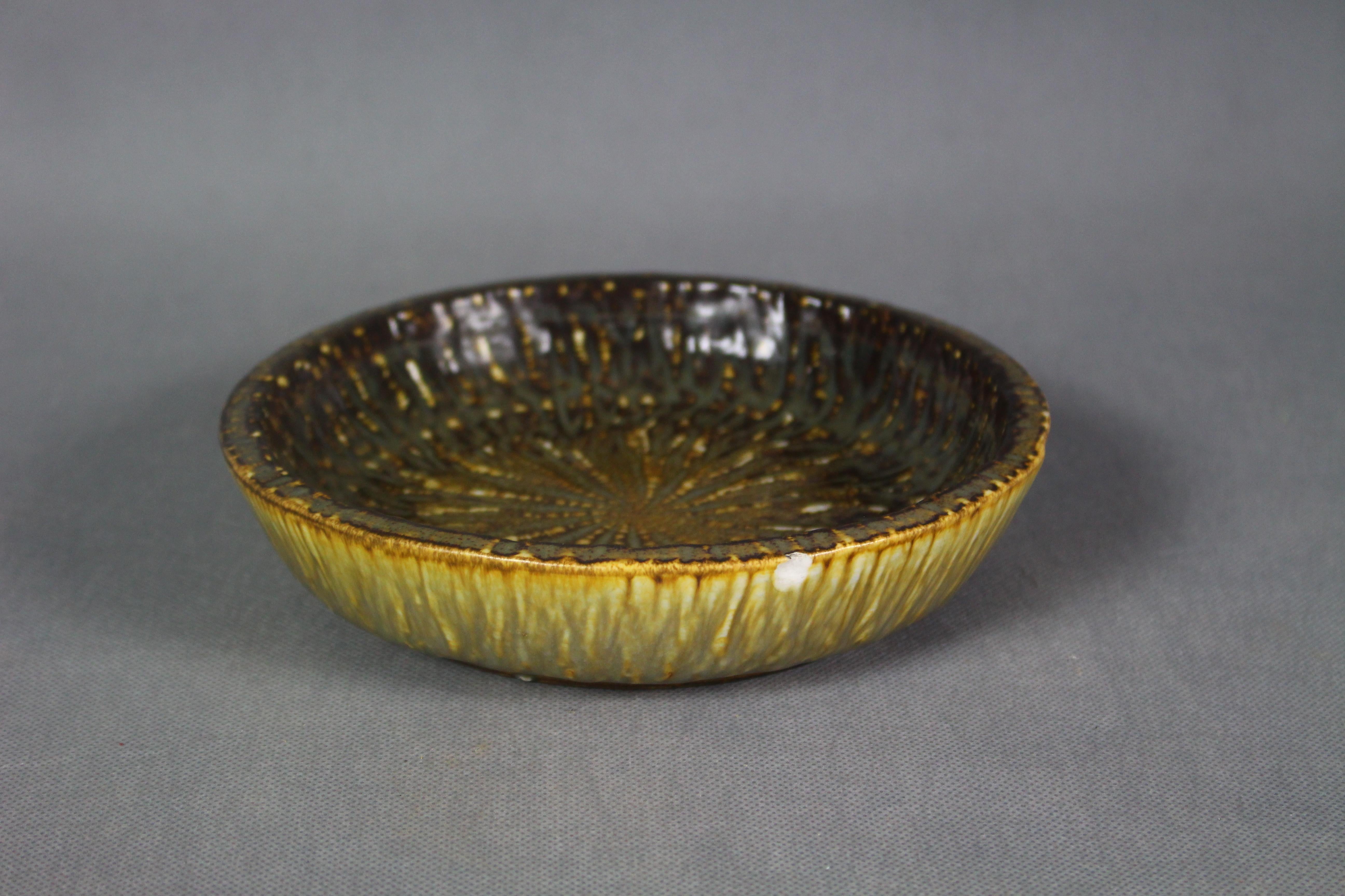 Gunnar Nylund bowl in earth tone colors, matte glazed in brown and yellow. This bowl is made by ceramics artist Gunnar Nylund for Swedish porcelain and stoneware factory Rorstrand (Rörstrand) in the 1940s and the series is called Chamotte.
 
