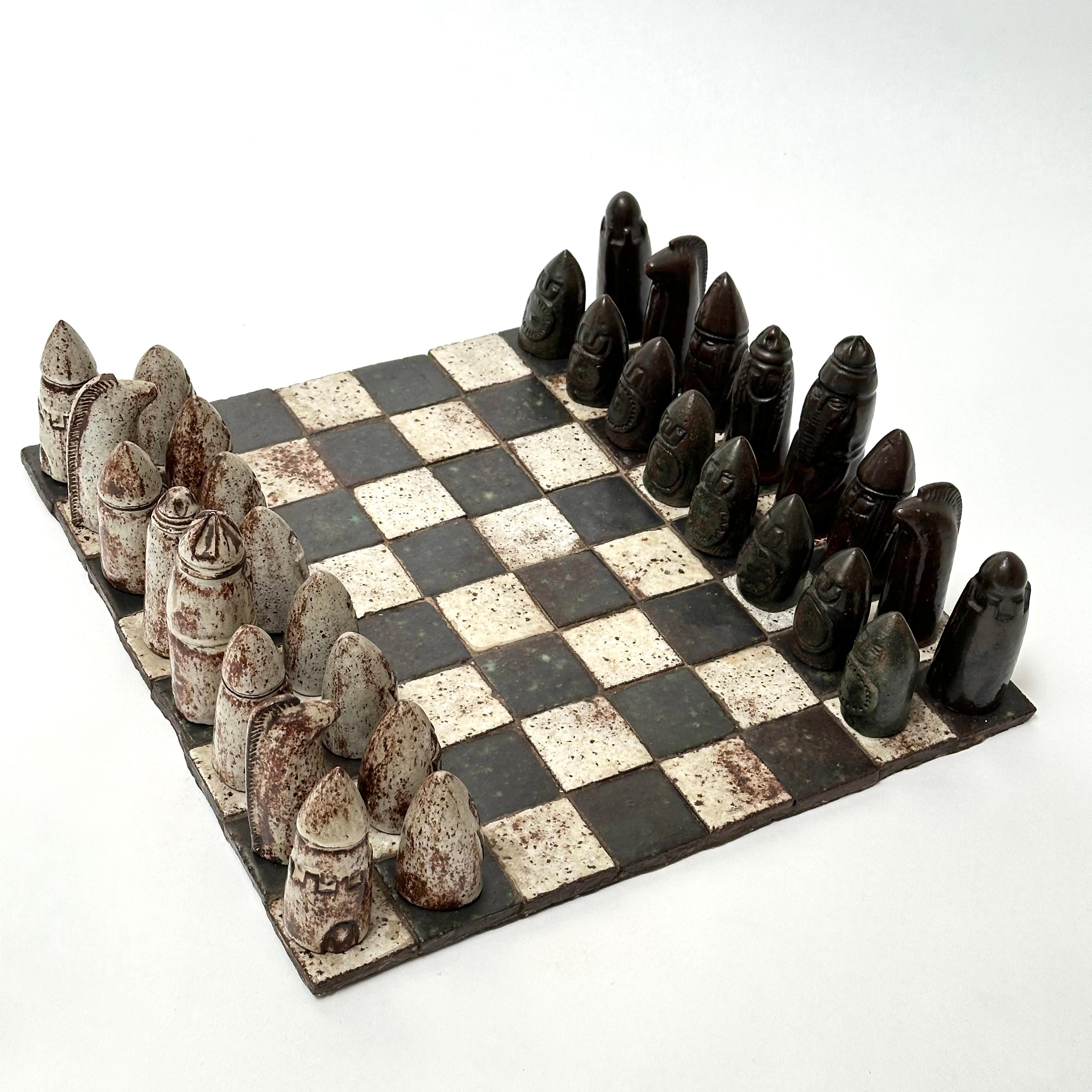 Exceptional achievement in modeled stoneware with great attention to details giving each piece an intrinsic decorative value.

Handwritten signature on the back of the chessboard.

Measurements (cm) : from 14 for the kings to 8 for the pawns.

The