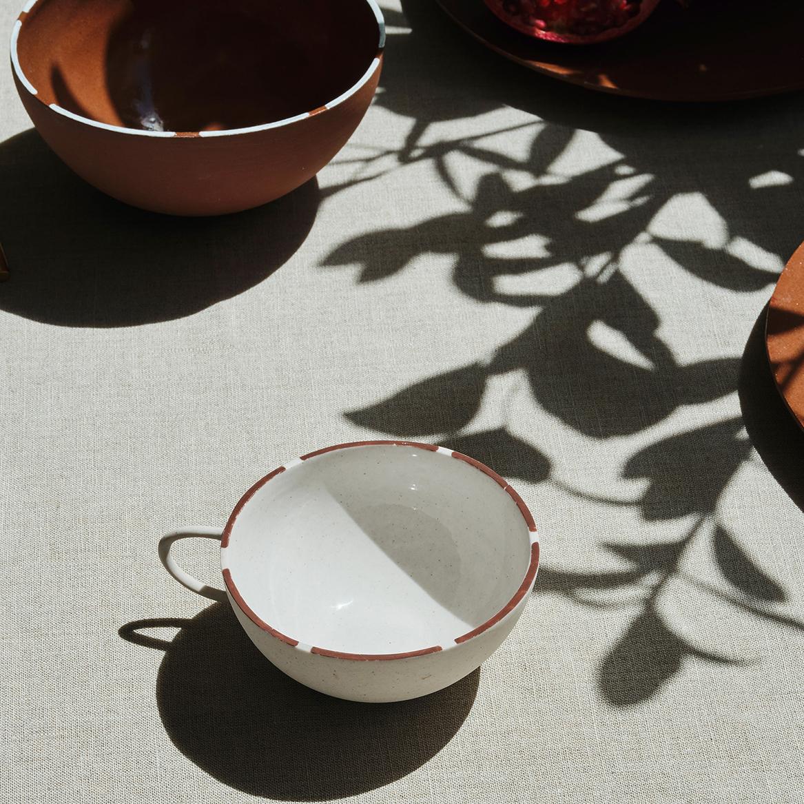 The pieces are slip cast in London, made from stoneware in small batches. The hand painted details around the rim of each item in the collection is created by glaze in a complimentary colour to the body of each piece.

CUSTHOM studio has developed