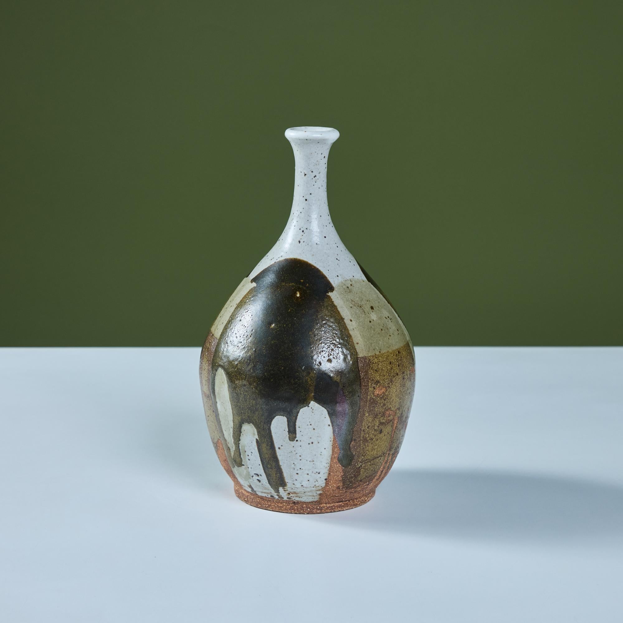 Ce vase en grès tourné à la main est doté d'un petit bec verseur et d'un regard goutte à goutte de différentes couleurs sur toute la forme, en brun, vert et ciment moucheté.

Dimensions
5,5