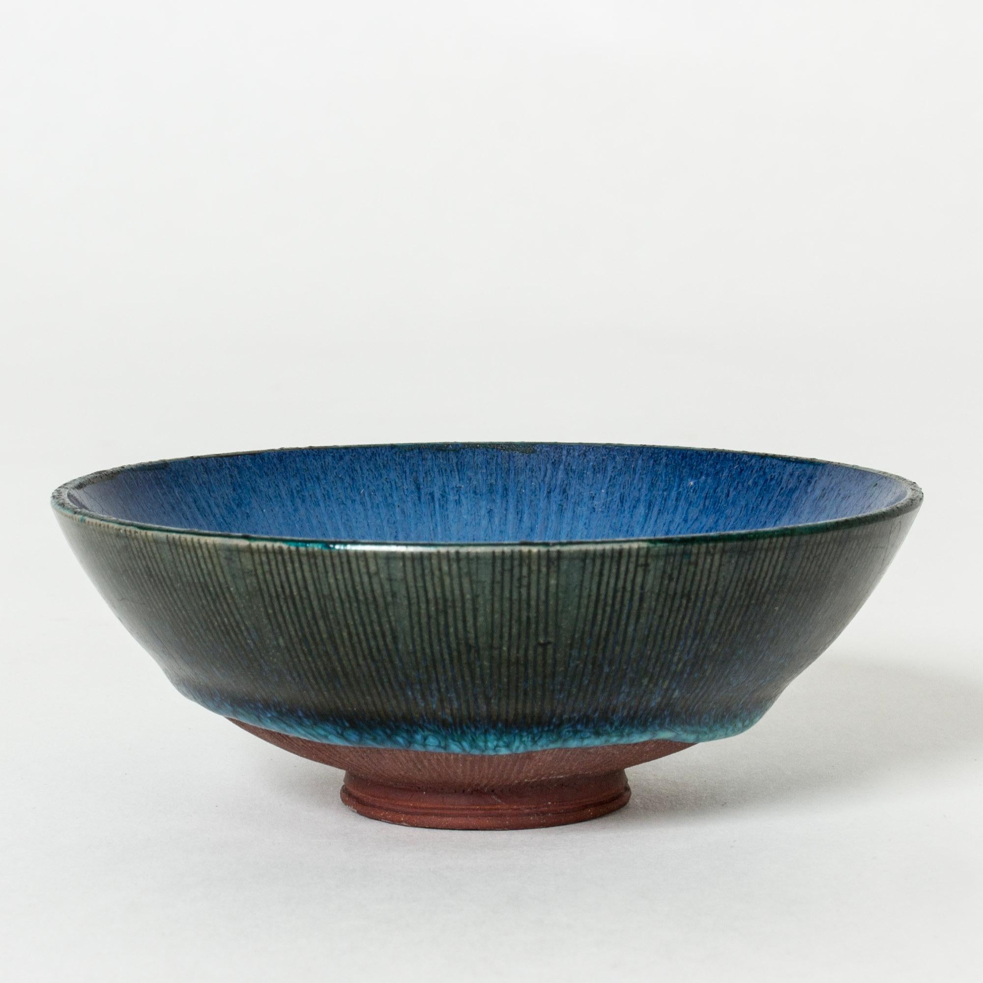 Lovely, small stoneware bowl by Wilhelm Kåge. Unglazed base and inside in vibrant, glossy blue coming over the edge and gathering in a thicker drip close to the bottom.

“Farsta” stoneware is recognized as being the best and most exclusive that has