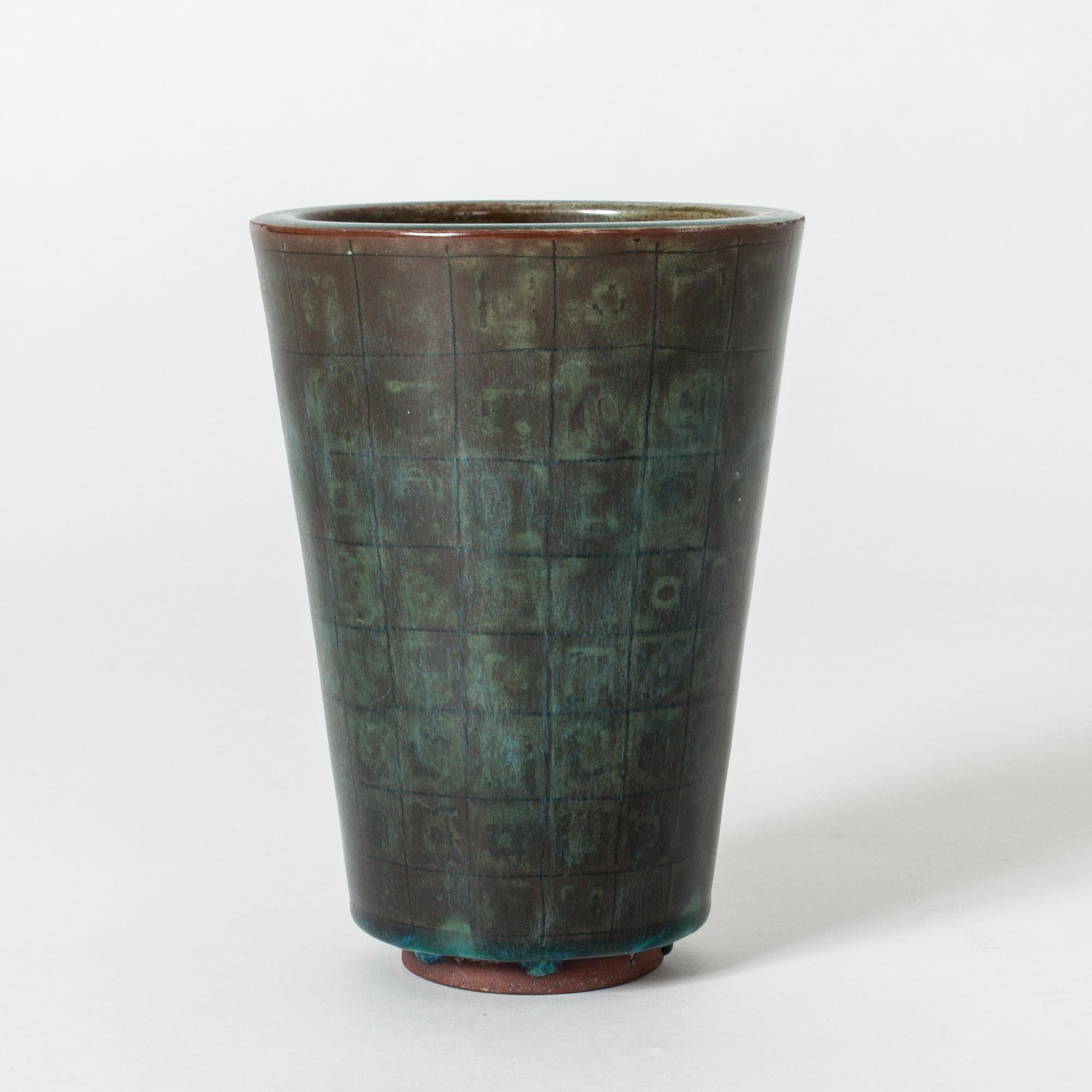 Simple yet striking “Farsta” vase by Wilhelm Kåge with clean lines and a subtle checkered pattern in the dark, patinated copper colored glaze.

“Farsta” stoneware is recognized as being the best and most exclusive that has come out of Swedish arts