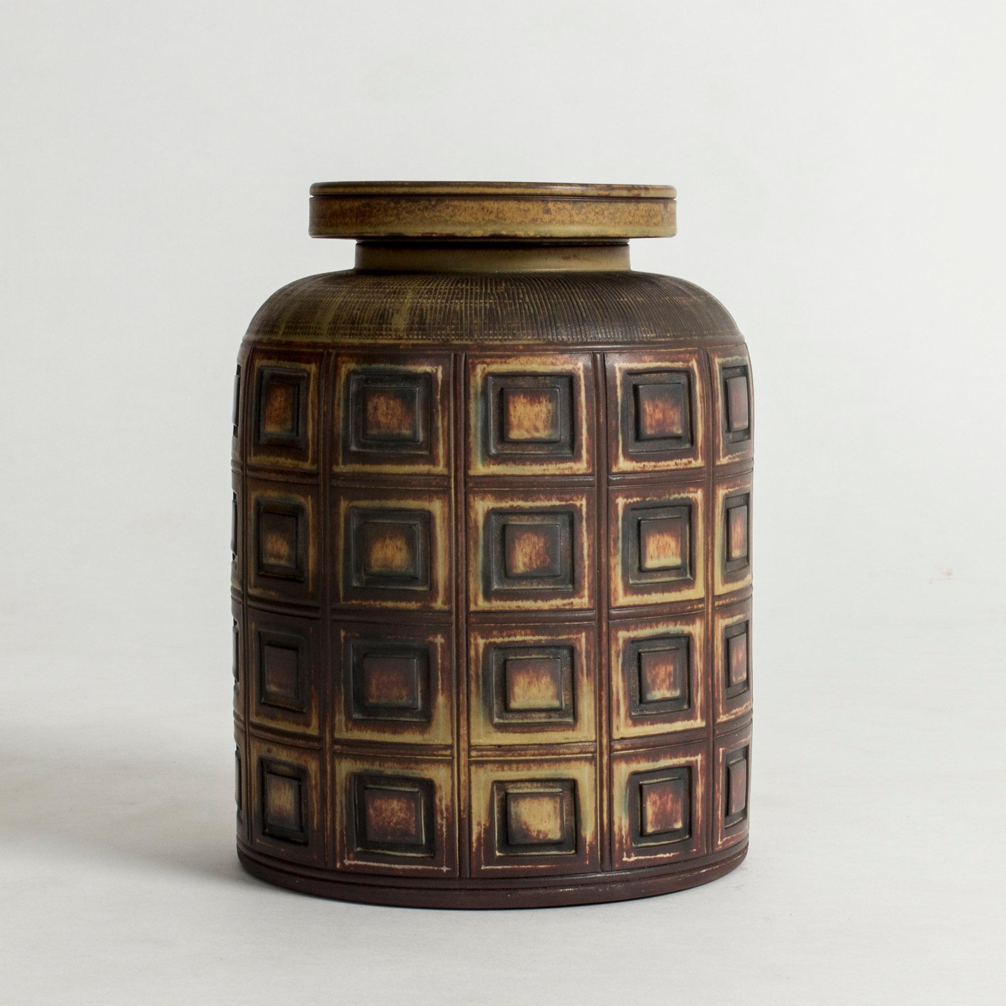 Striking lidded “Farsta Rust” vase by Wilhelm Kåge, in a robust design with a pattern of embossed squares.

“Farsta” stoneware is recognized as being the best and most exclusive that has come out of Swedish arts and crafts. The series represents