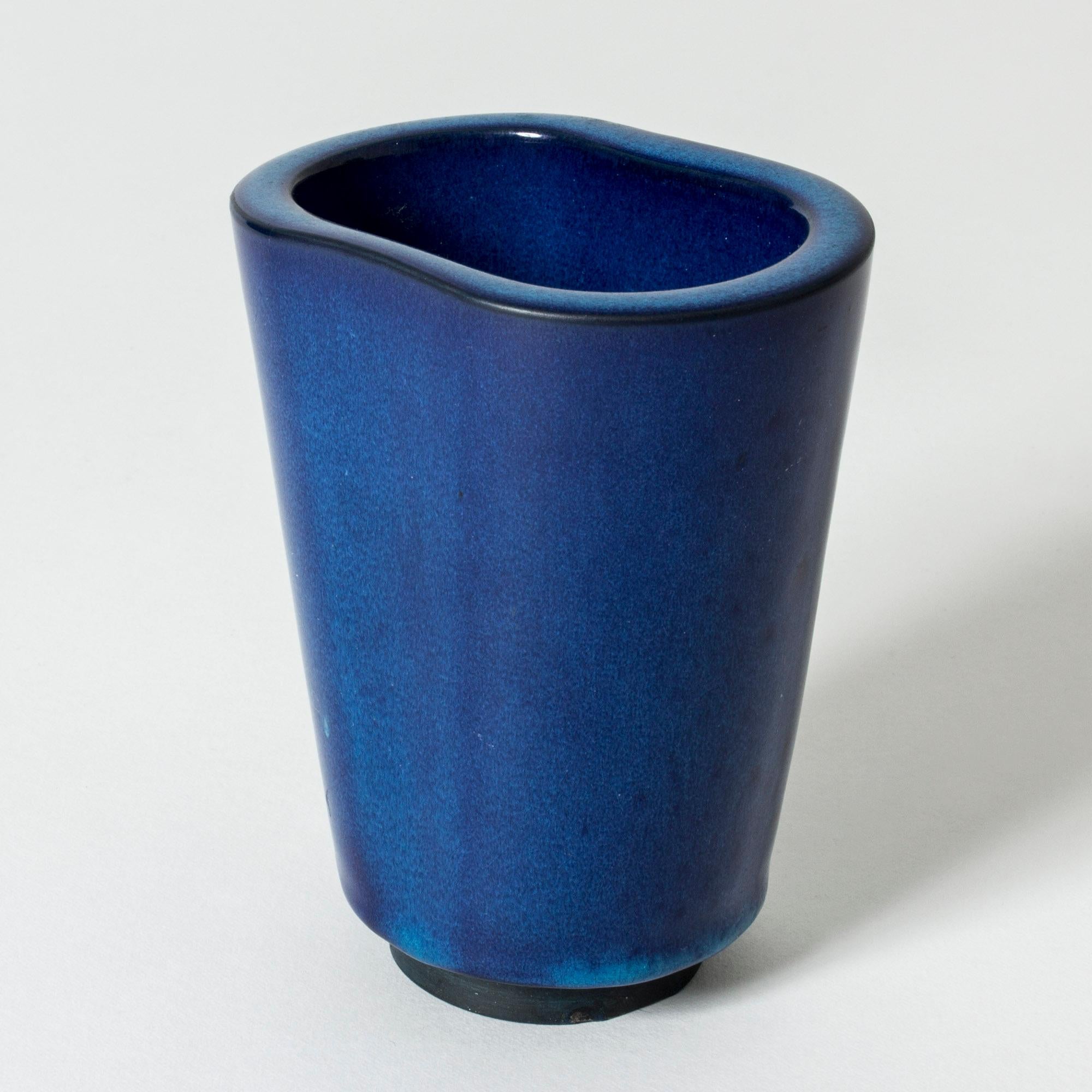 Striking “Farsta” vase by Wilhelm Kåge, in a tapering form with thick sides. Rich blue glaze gathering in drops around the base.

“Farsta” stoneware is recognized as being the best and most exclusive that has come out of Swedish arts and crafts.