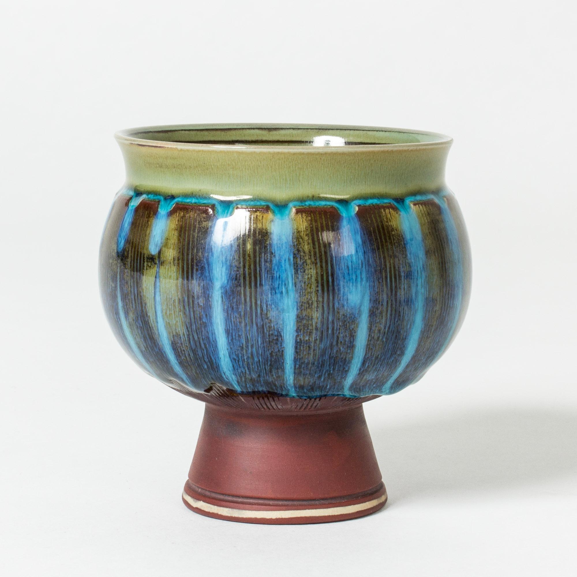“Farsta” vase with thick, blue glazed walls balancing on an unglazed base decorated with etched stripes. Production year inscripted on the base.

“Farsta” stoneware is recognized as being the best and most exclusive that has come out of Swedish arts