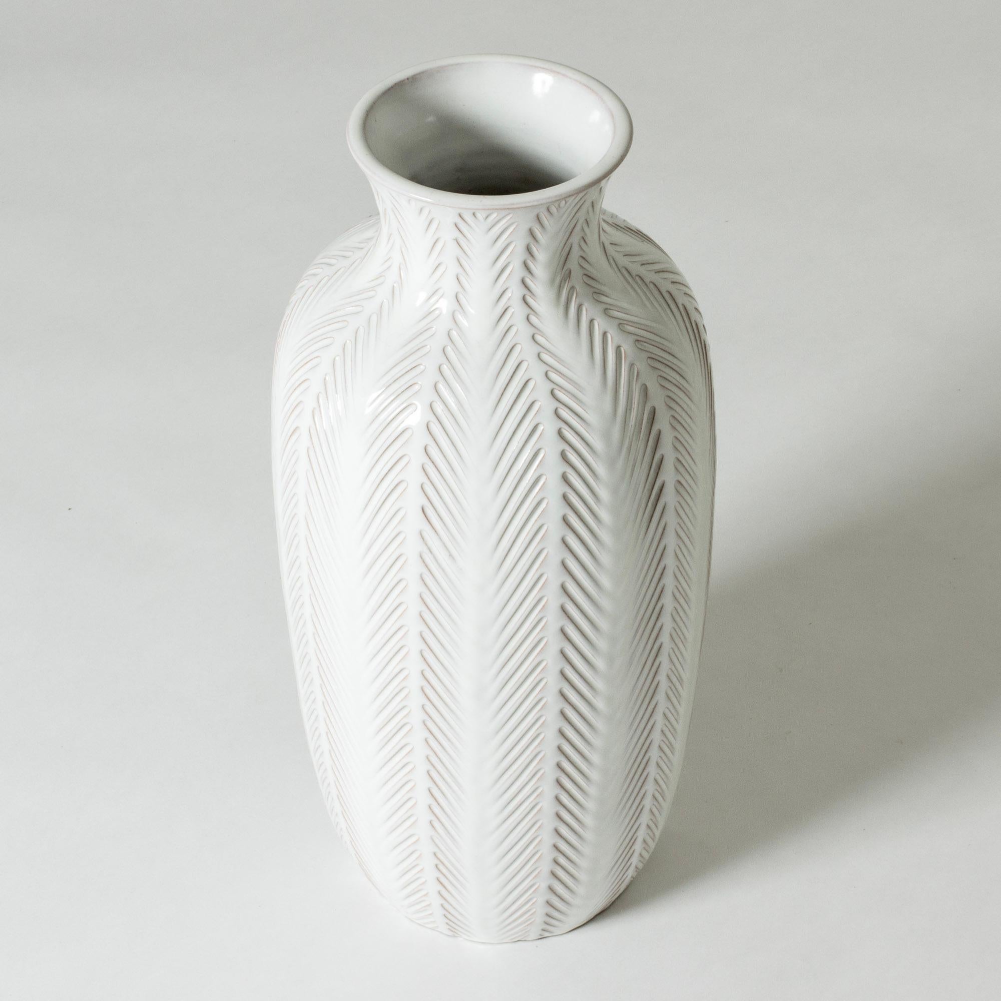 Beautiful stoneware floor vase by Anna-Lisa Thomson, glazed white. Decorative embossed graphic pattern.

The artist Anna-Lisa Thomson is best known for her stoneware and earthenware for Upsala-Ekeby where she worked from the mid 1930s until her