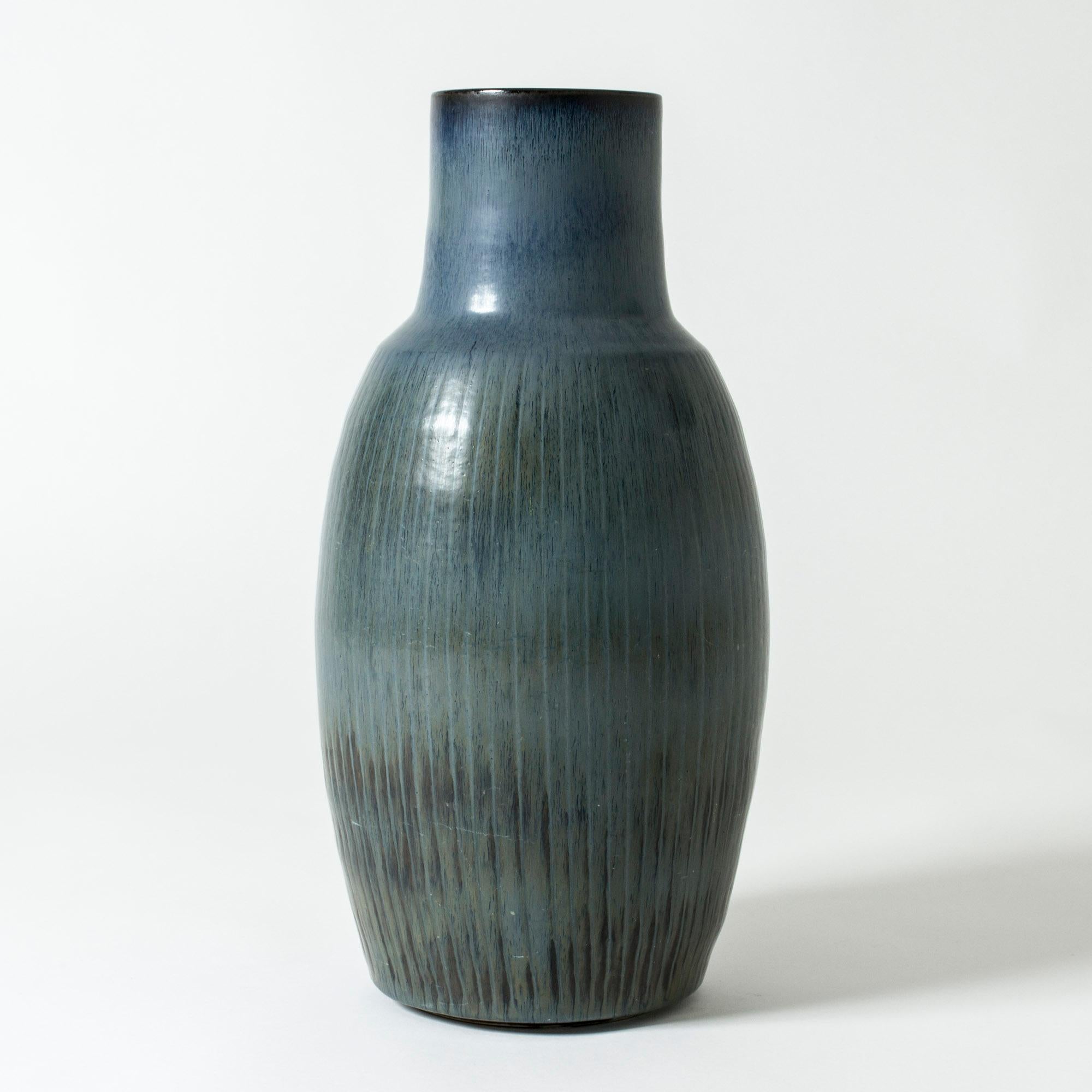 Large stoneware floor vase by Carl-Harry Stålhane in a stout form with dark petroleum colored glaze. Pattern of embossed stripes.

Carl-Harry Stålhane was one of the stars among Swedish ceramic artists during the 1950s, 1960s and 1970s, whose