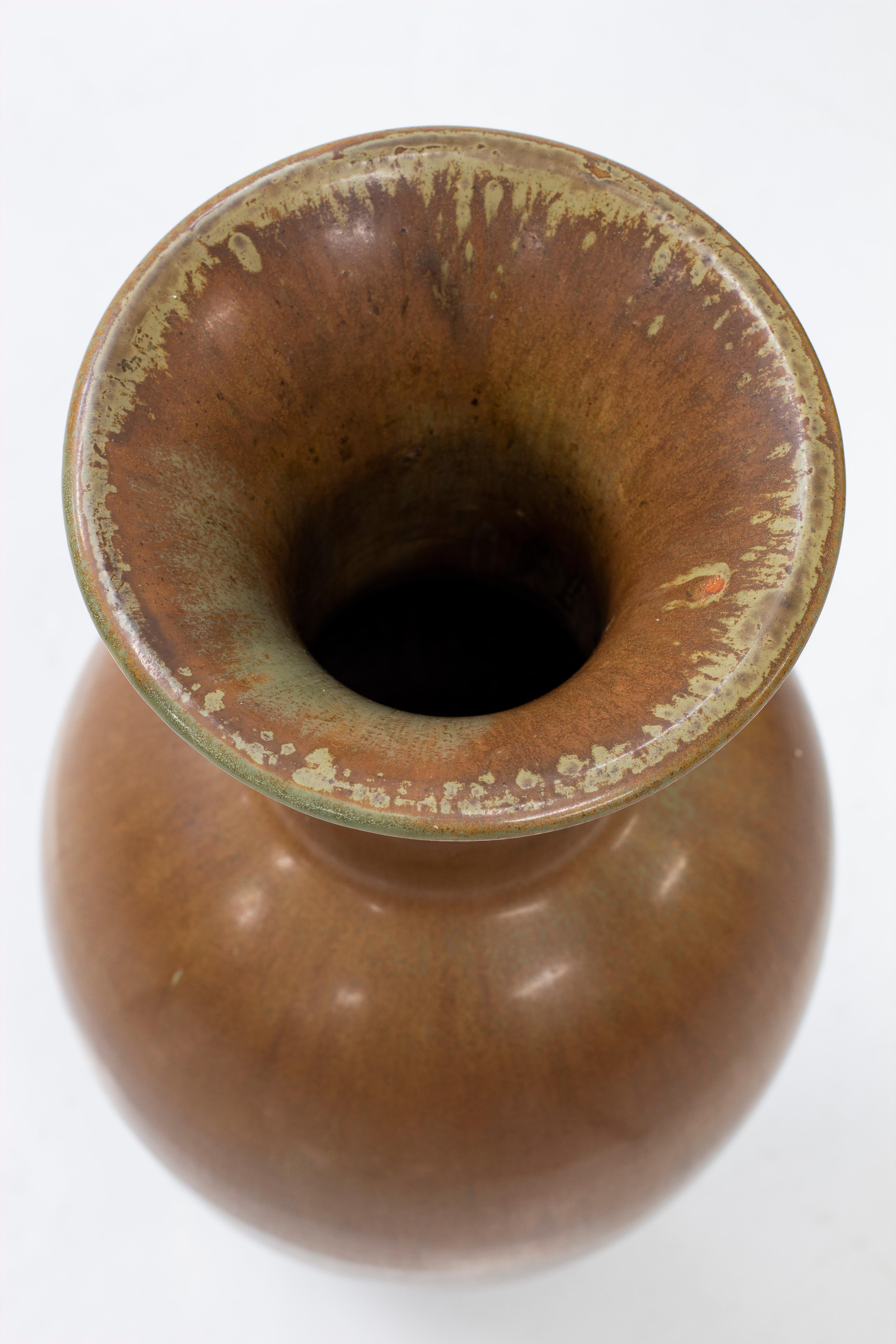 Grand vase de sol conçu par Gunnar Nylund. Modèle rare et le plus grand qui a été conçu par Nylund et produit en série par Rörstrand dans les années 1950. Rare glaçure polychrome changeant dans les tons verts, bruns et jaunes. Première ligne de