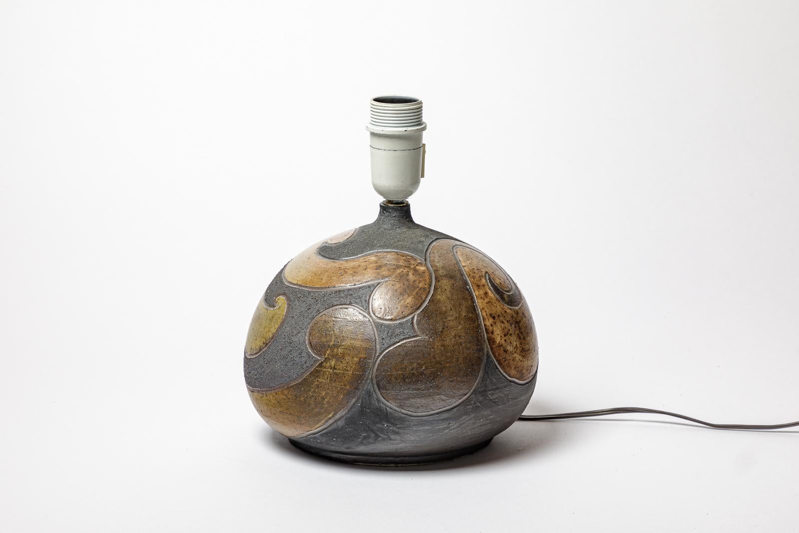 Lampe en grès à décor géométrique par Georges Martin.
Monogramme de l'Artistics sur la base. Circa 1970-1980.
H : 7.1 x 8.7 pouces (céramique uniquement).
Vendu avec un système électrique européen.