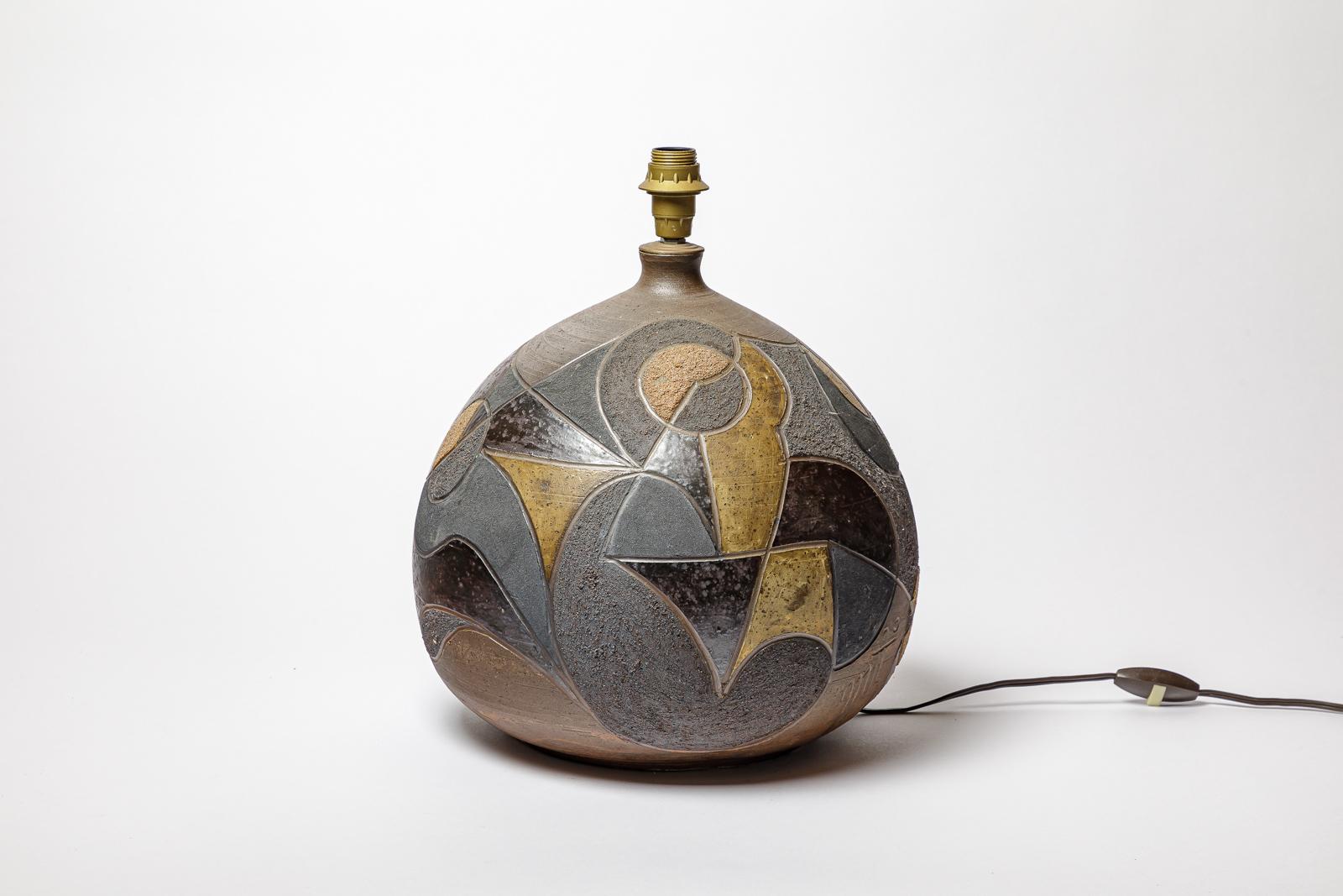 Lampe en grès à décor géométrique par Georges Martin.
Monogramme de l'Artistics sur la base. Circa 1970-1980.
H : 11.8 x 11.4 pouces (céramique uniquement).
Vendu avec un système électrique européen.
